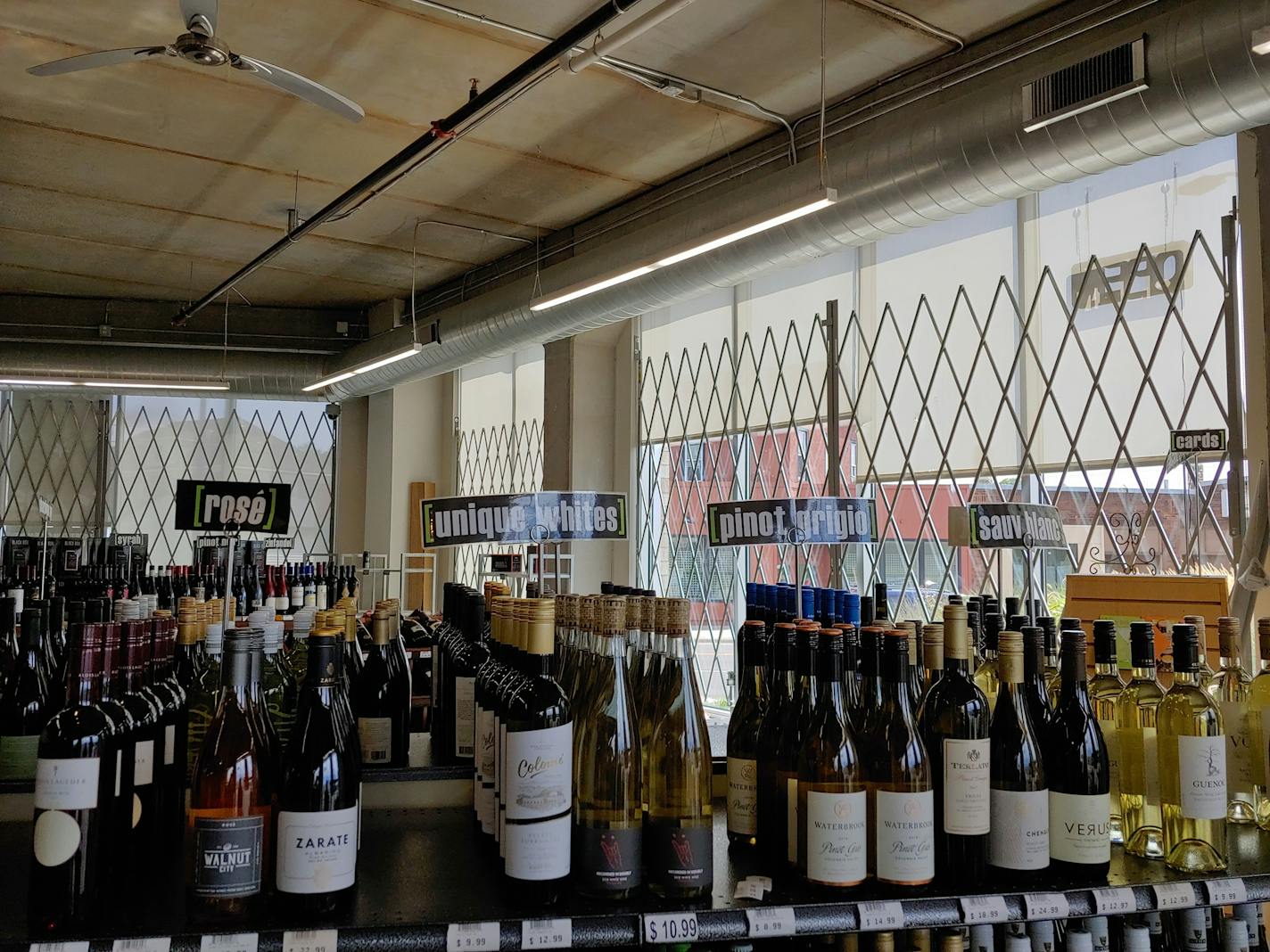 Metal gates inside the windows at Broadway Liquor Outlet in Minneapolis. Business owners lament that they are unable to use exterior shutters, which they believe will perform better in blocking entrances to their shops while also protecting their windows. Photo by Jeffrey Meitrodt.