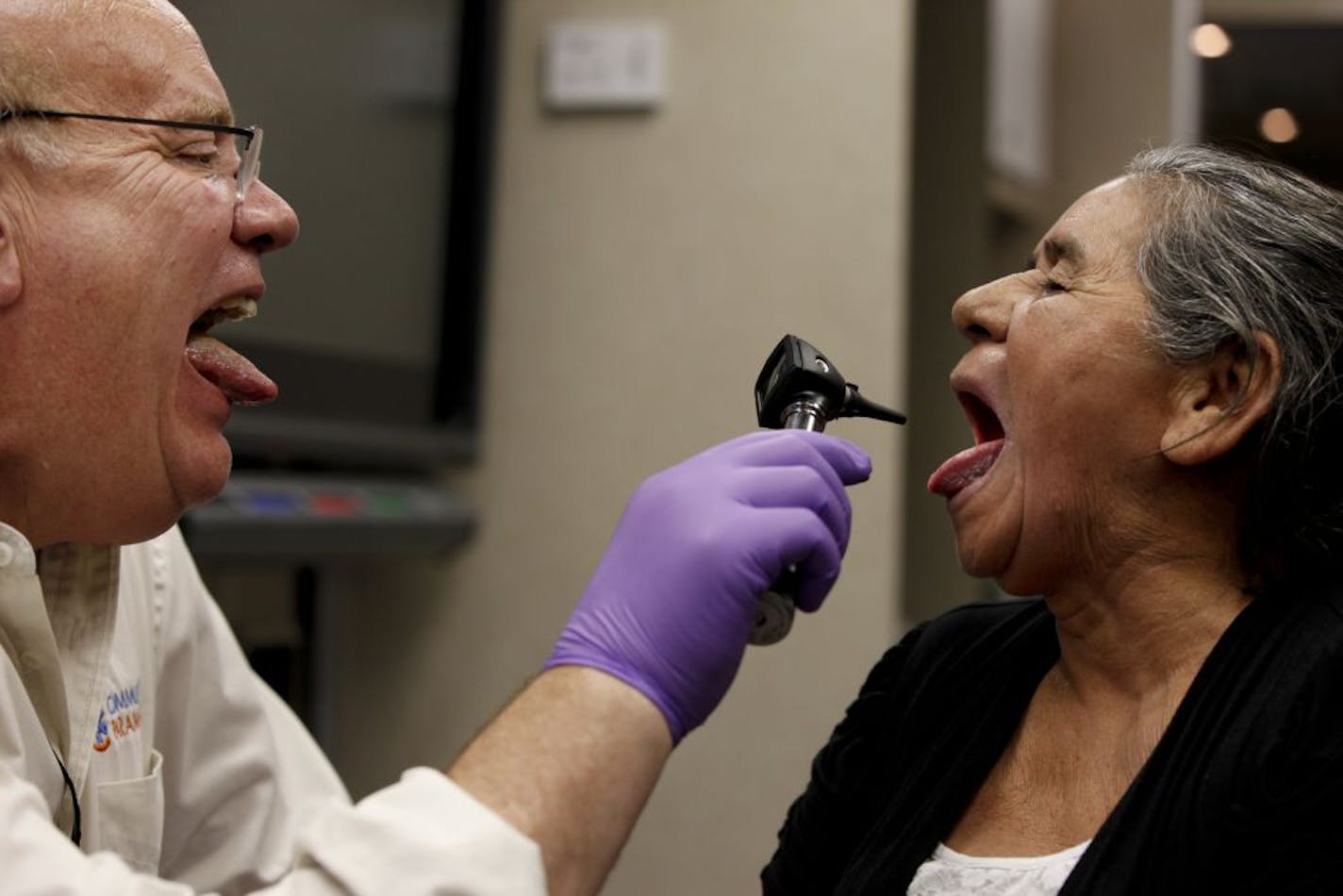 Dominga Ruiz mimics her doctor as community paramedic Kai Hjermstad performs a routine check in the Shakopee Mdewakanton Sioux mobile health van.