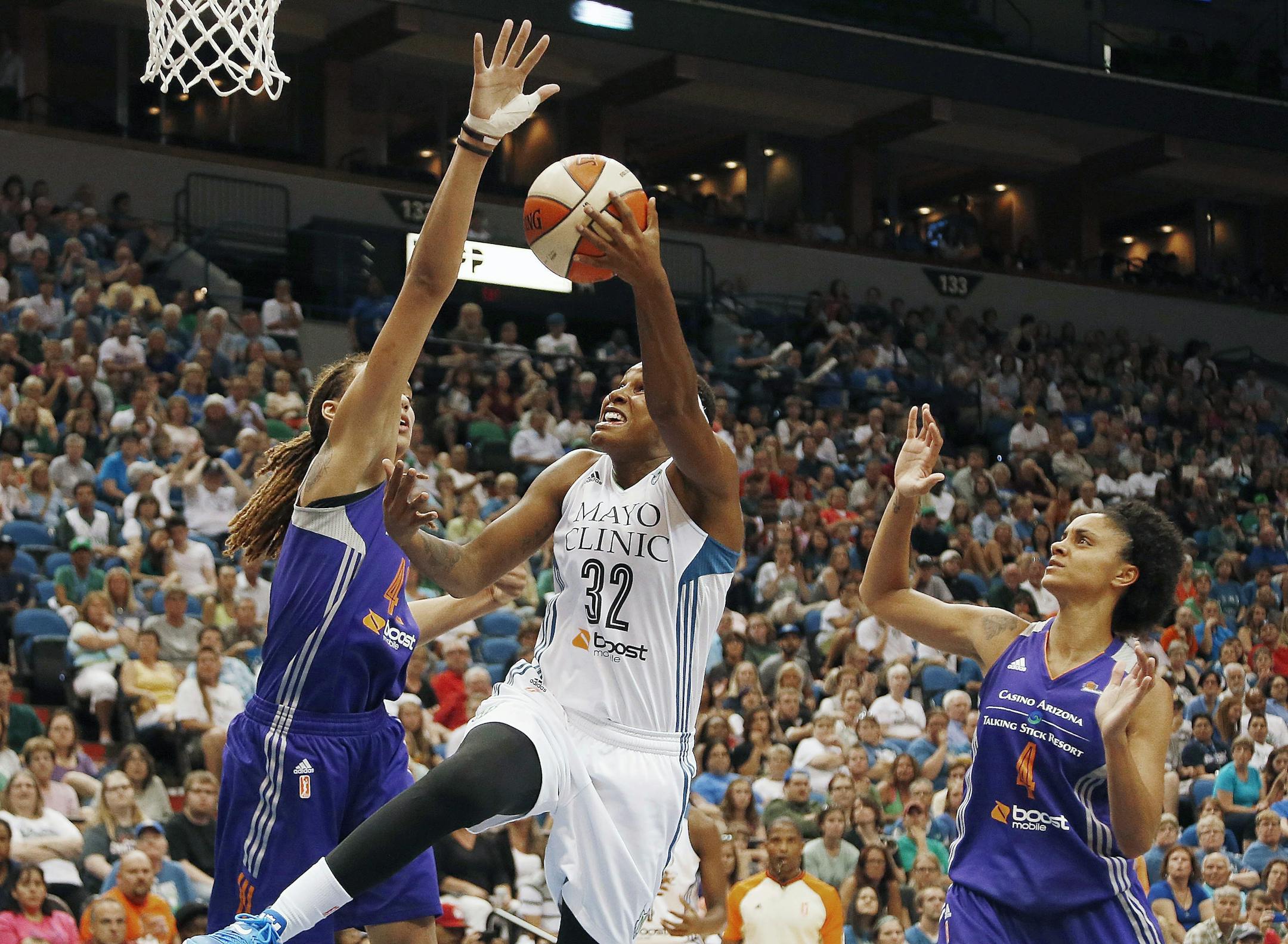 Minnesota Lynx forward Rebekkah Brunson (32) goes up to the basket against Phoenix Mercury center Brittney Griner (42) and forward Candice Dupree in the second half of a WNBA basketball game, Thursday, July 31, 2014, in Minneapolis. The Lynx won 75-67. (AP Photo/Stacy Bengs)