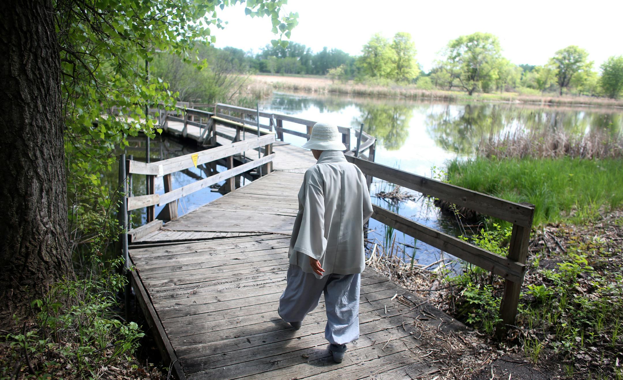 A Korean Buddhist nun walked along a path as she and another nun took pictures of some of the wild flowers. ] (KYNDELL HARKNESS/STAR TRIBUNE) kyndell.harkness@startribune.com Springbrook Nature Center in Fridley, Min. Wednesday, May 28, 2014. The City of Fridley's Springbrook Nature Center will receive $5 million in state bonding to add on to their interpretative center.