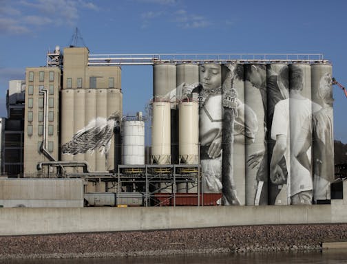 Australian artist Guido van Helten has finished a colossal piece covering the Ardent Mills silos in Mankato.