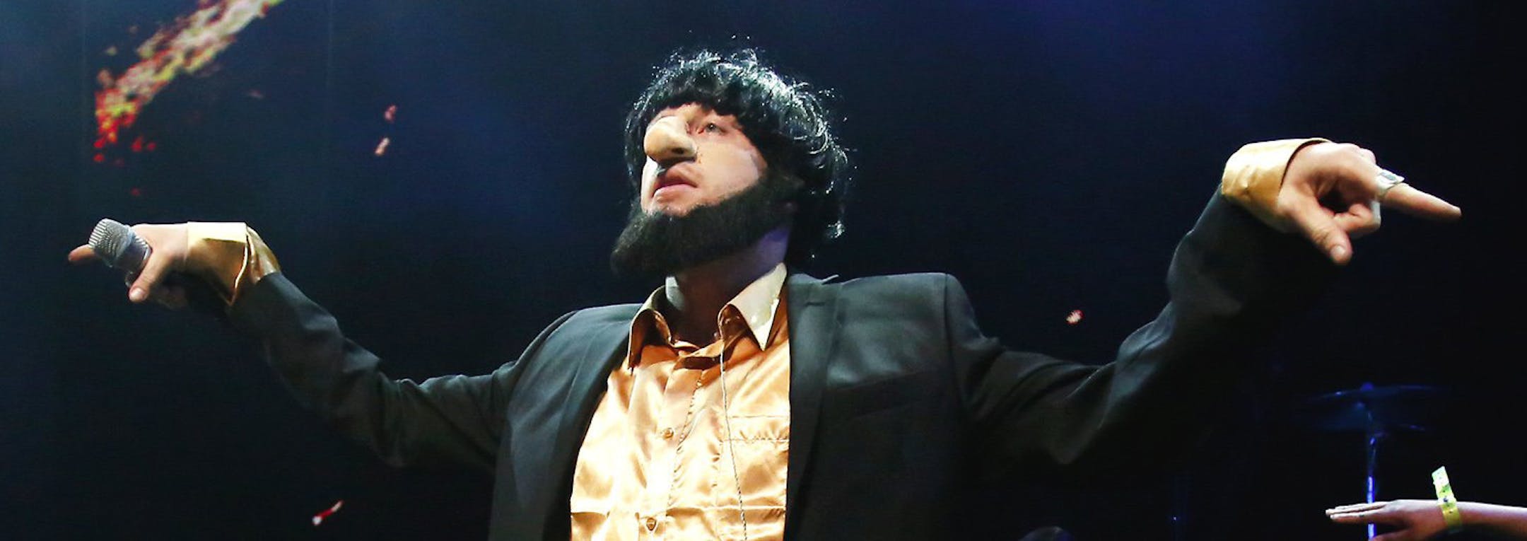 In this photo taken May 16, 2014, Macklemore of the group Macklemore & Ryan Lewis strikes a pose as he performs "Thrift Shop" to a mob of waving fans during Vivid: Spectacle Opening Night Party at the EMP Museum in Seattle. (AP Photo/The Seattle Times, Lindsey Wasson) SEATTLE OUT; USA TODAY OUT; MAGS OUT; TELEVISION OUT; NO SALES; MANDATORY CREDIT TO BOTH THE SEATTLE TIMES AND THE PHOTOGRAPHER.