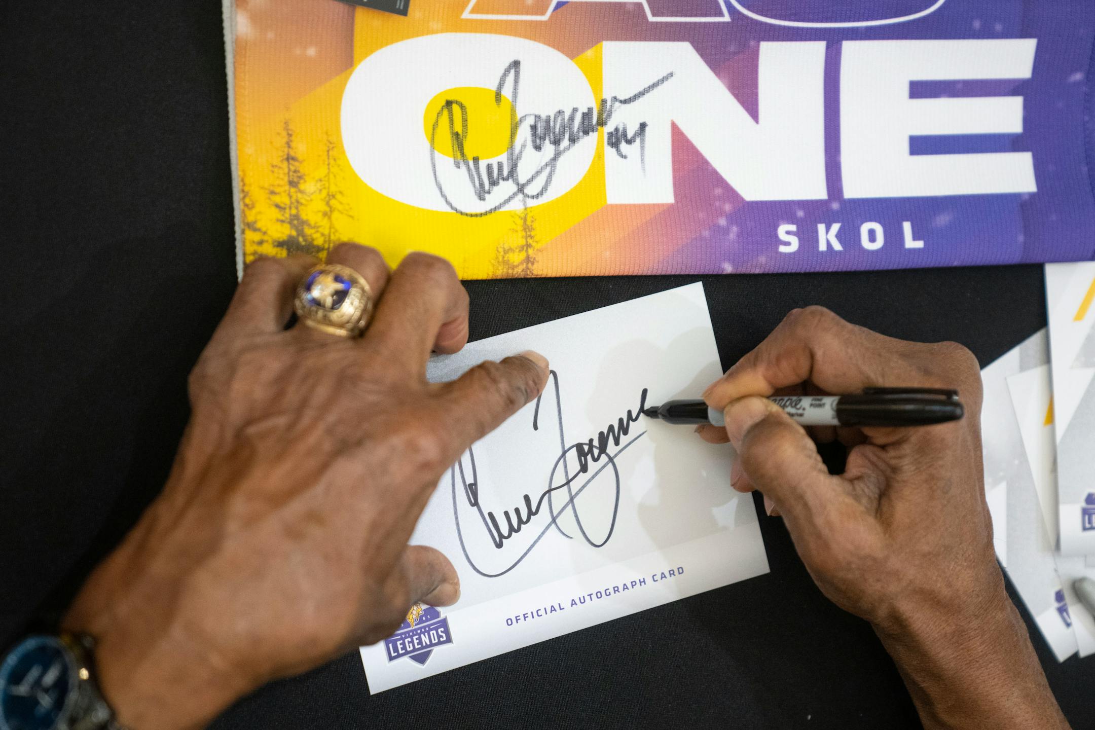 Chuck Foreman, a former Minnesota Vikings running back, signs autographs during a Vikings fan rally.