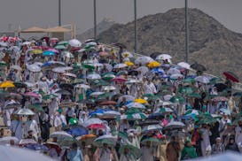 Muslim pilgrims use umbrellas to shield themselves from the sun as they arrive to cast stones at pillars in the symbolic stoning of the devil, the las