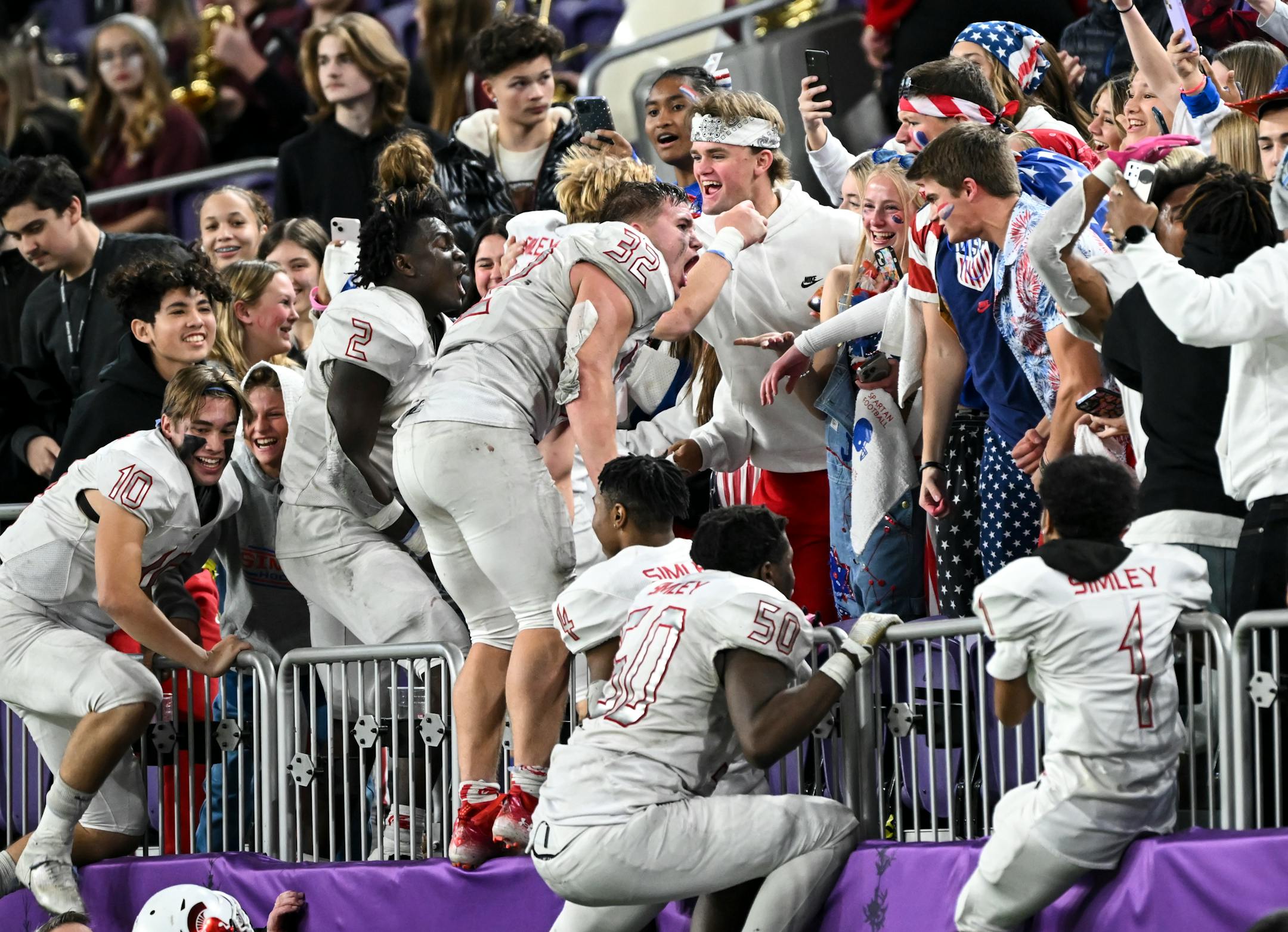 Simley players jump in the stands after defeating Rocori in a Class 4A semifinal playoff game.