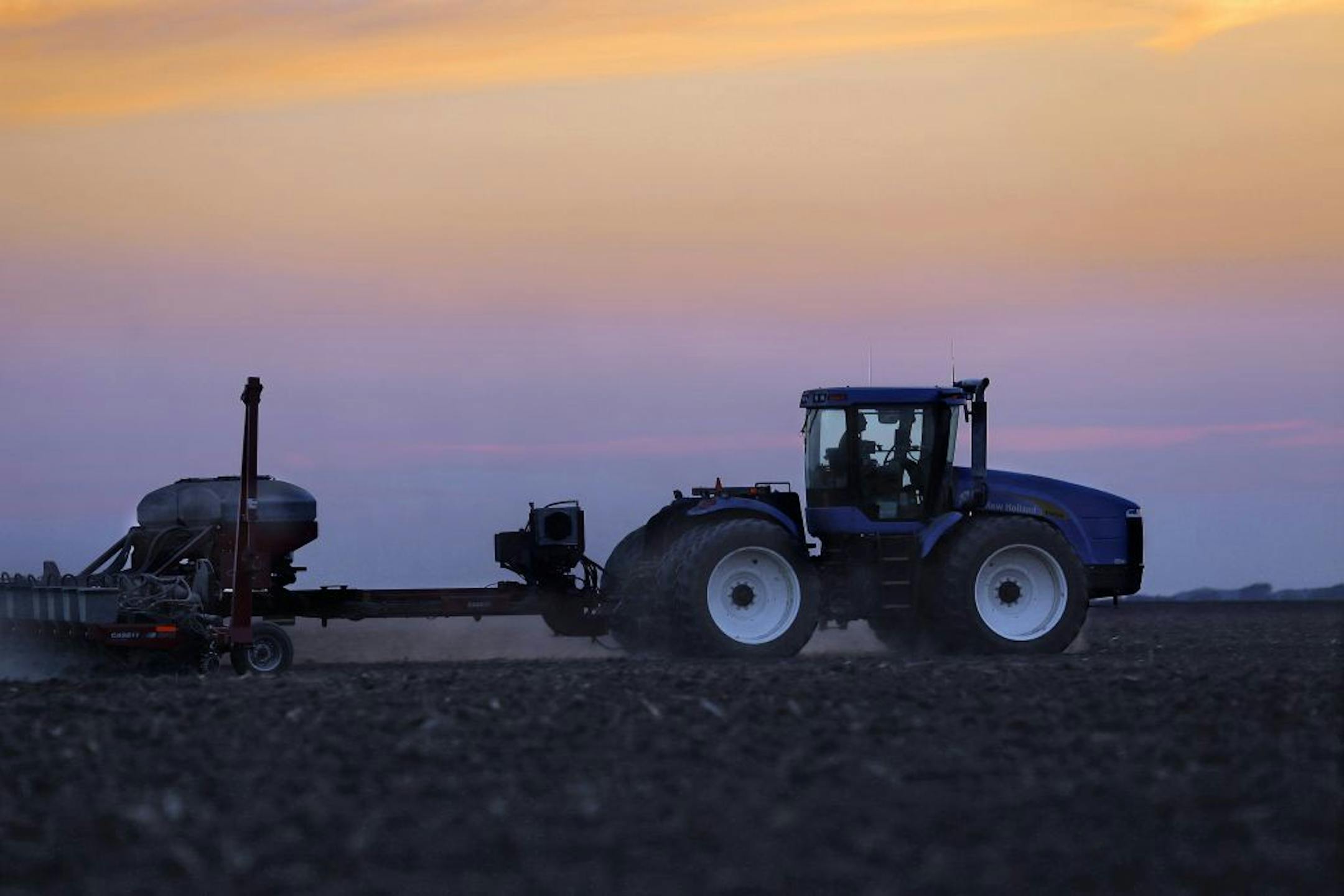 In this Saturday, June 8, 2013 photo, a central Illinois farmer continues planting corn seed into the evening in Farmingdale, Ill. The USDA releases its monthly update on planted acres and yield expectations on Wednesday. The report could reflect the impact of a very wet spring in the Midwest on corn and soybeans harvested per acre and the crop yields that reflect late planting which could reduce production because the crops have less time to fully develop. These estimates could send prices for