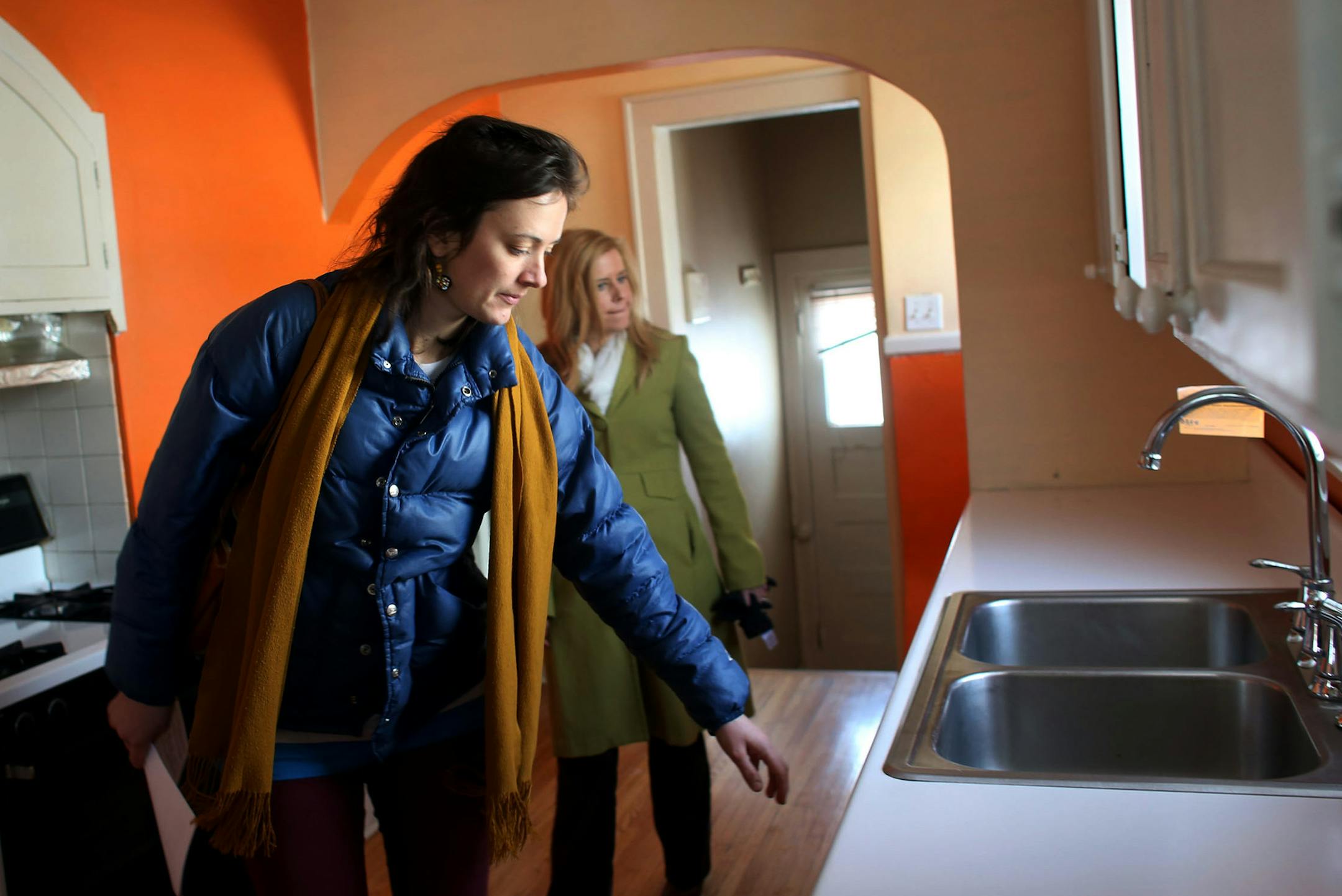 With real estate agent Emily Green, behind her potential home buyer Rishona Millard took a closer look at the kitchen in a house for sale on 5th Ave S in Minneapolis Saturday, January 11, 2014. ] (KYNDELL HARKNESS/STAR TRIBUNE) kyndell.harkness@startribune.com ORG XMIT: MIN1401131213561605