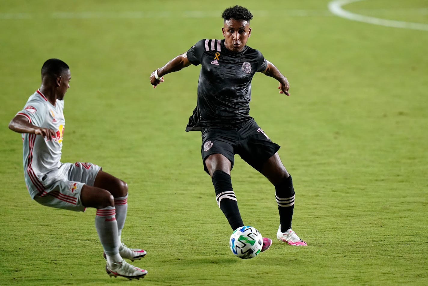 Inter Miami forward Juan Agudelo, right, kicks the ball as New York Red Bulls' Jason Pendant defends during the first half of an MLS soccer match, Wednesday, Sept. 23, 2020, in Fort Lauderdale, Fla. (AP Photo/Lynne Sladky)