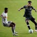 Inter Miami forward Juan Agudelo, right, kicks the ball as New York Red Bulls' Jason Pendant defends during the first half of an MLS soccer match, Wed