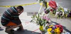 Noah Nicolaisen, of Charleston, S.C., kneels at a makeshift memorial, Thursday, June 18, 2015, down the street from where a man opened fire Wednesday 