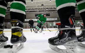 Rock Ridge’s Grant Gerlach, center, passes away the puck during practice Feb. 22, 2022, at the Iron Trail Motors Event Center in Virginia, Minn.