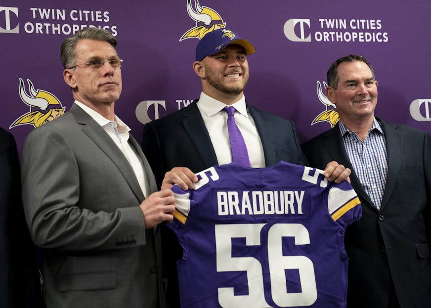 Minnesota Vikings first-round draft pick Garrett Bradbury holds his jersey with, from left, general manager Rick Spielman and head coach Mike Zimmer during a news conference at the TCO Performance Center News in Eagan, Minn., on Friday, April 26, 2019. (Renee Jones Schneider/Minneapolis Star Tribune/TNS)