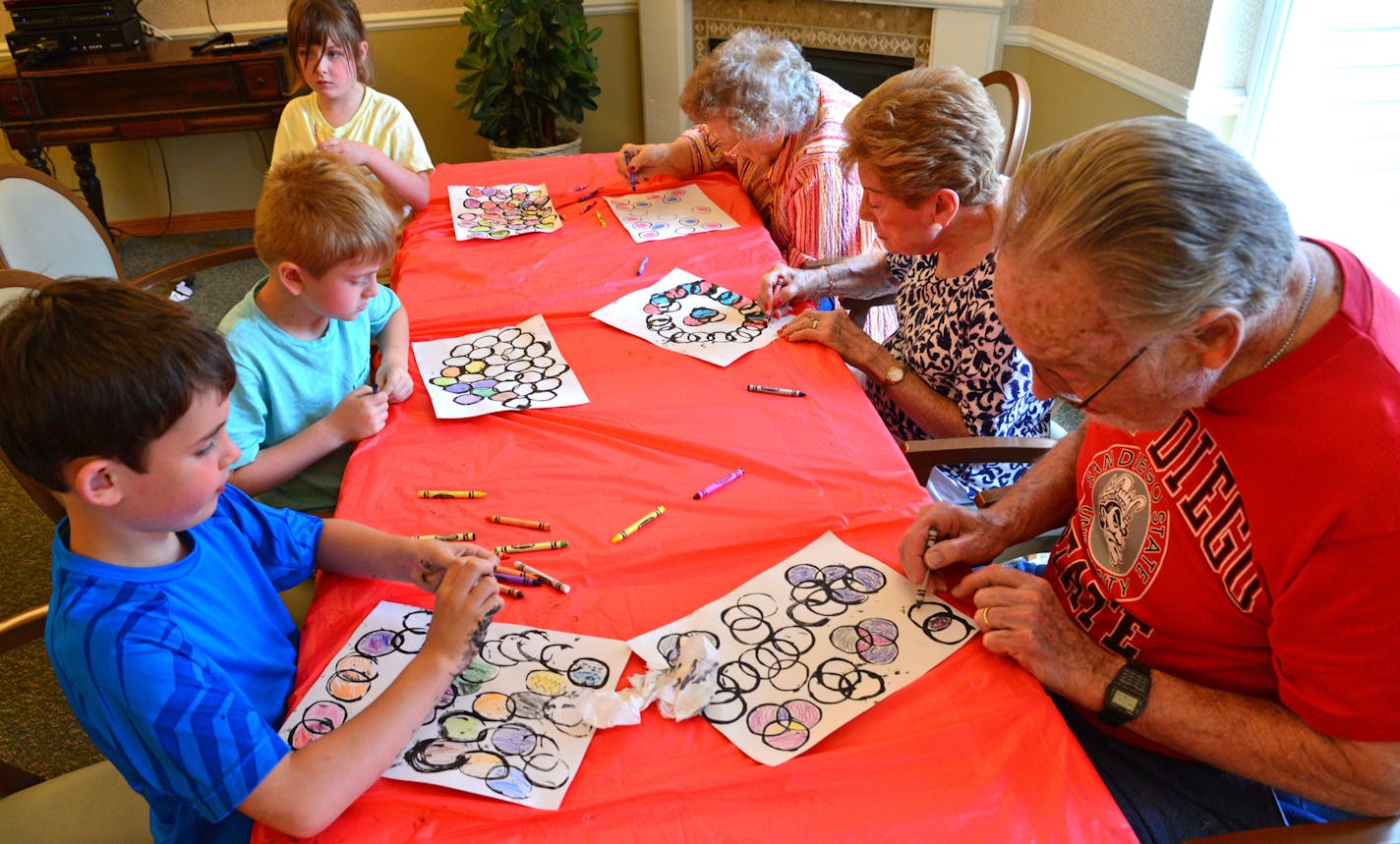 The art project was created with a toilet paper roll tube and black ink to create the circles which were colored in with crayons. ]Art Across the Ages is an Intergenerational art class with seniors and kids working together at the The Commons on Marice in Eagan. It's a bonding experience for young and old which helps children learn about the aging process. Richard.Sennott@startribune.com Richard Sennott/Star Tribune Eagan Minn. Thursday 6/12/2014) ** (cq)