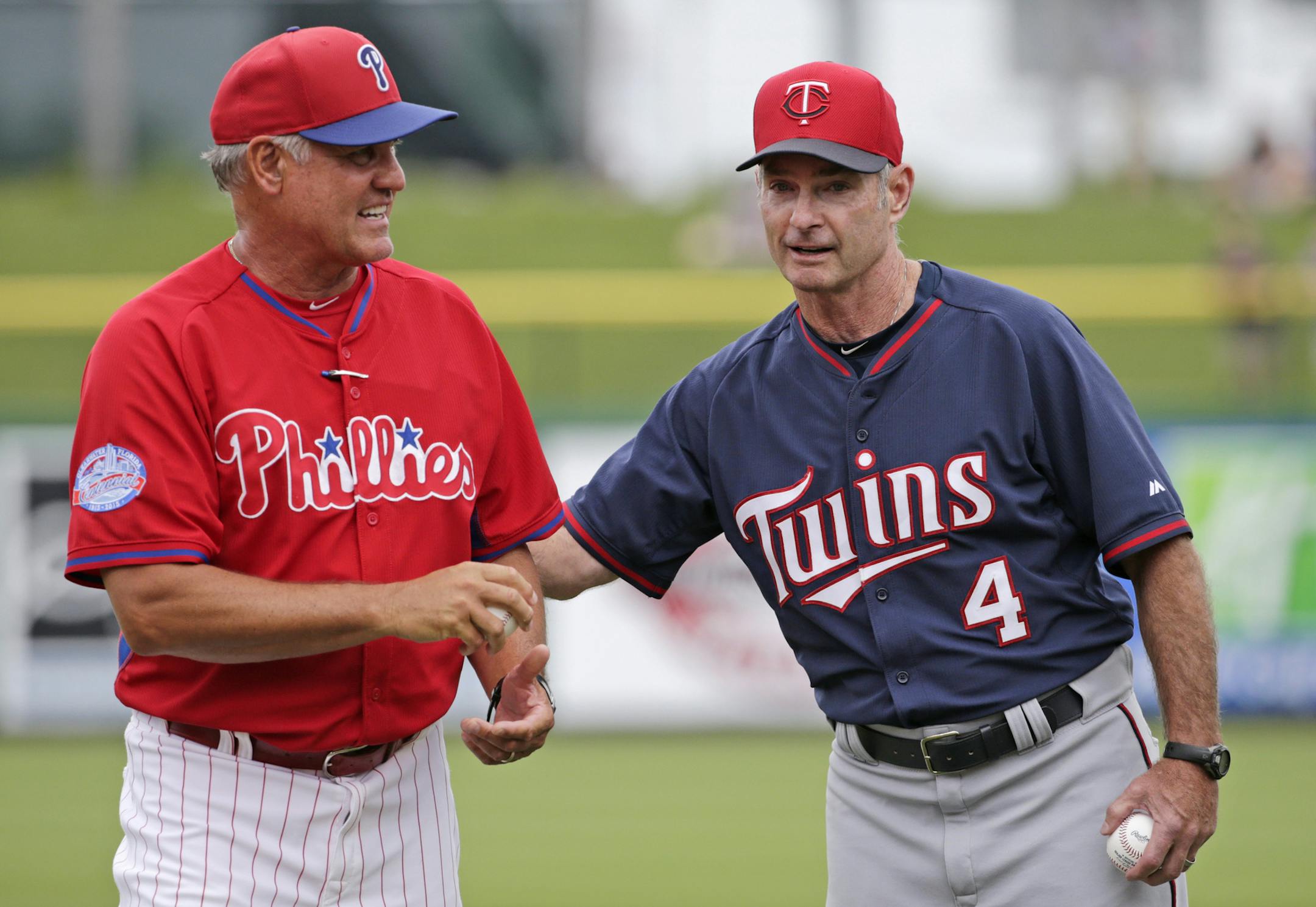 Philadelphia Phillies manager Ryne Sandberg, a 2005 Hall of Fame inductee, and Minnesota Twins manager Paul Molitor, a 2004 Hall of Fame inductee, talk before throwing out the ceremonial first pitches before a spring training baseball game between the Phillies and the Twins in Clearwater, Fla., Monday, March 23, 2015. It is the first time in Major League Baseball history two current Hall of Famers have managed a game against each other. (AP Photo/Kathy Willens)