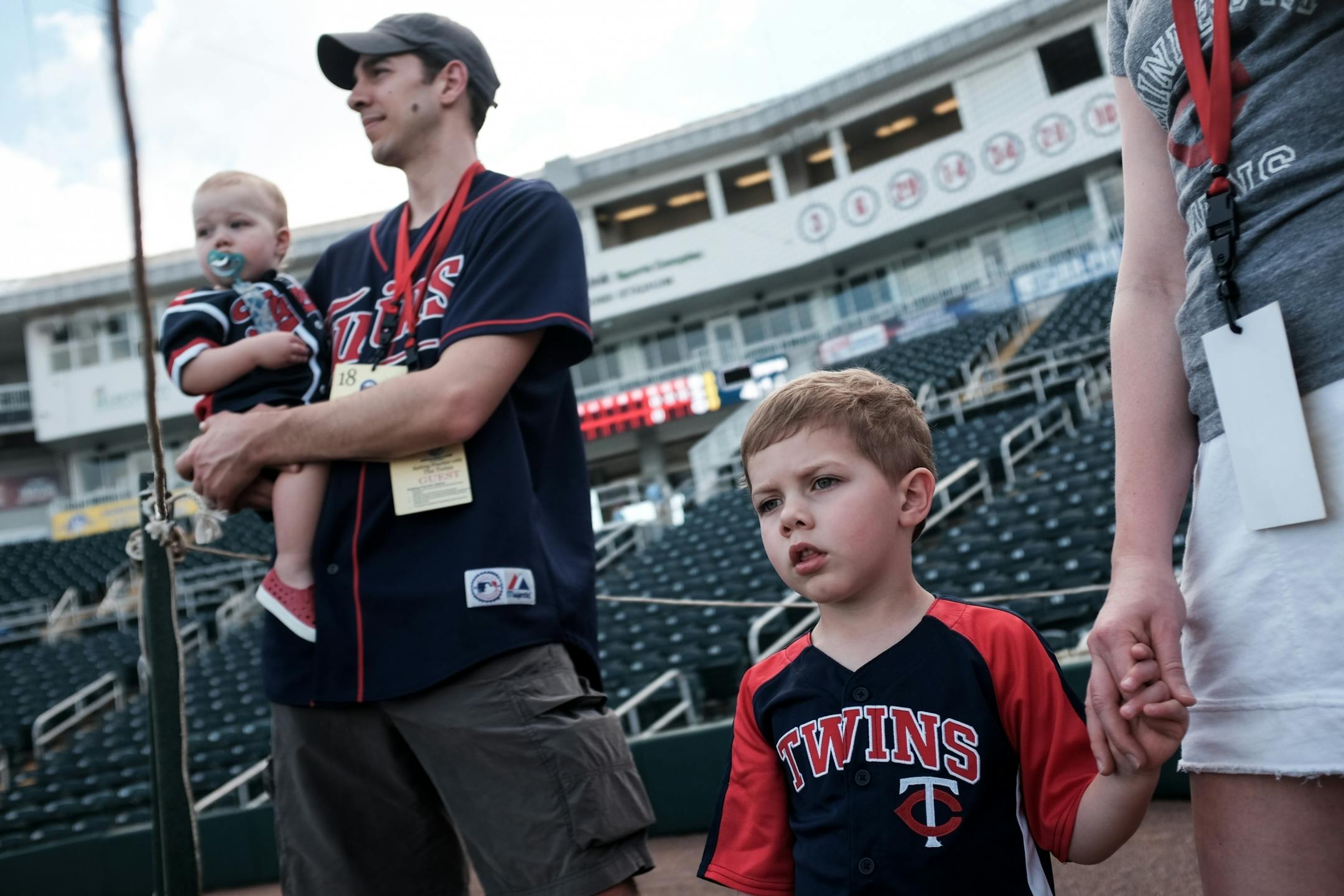 Luisa Fose held the hand of her 3-year-old son, Drew, as John Fose held their 1-and-a-half year old son, Brian, as the family watched the Twins' batting practice Friday evening.