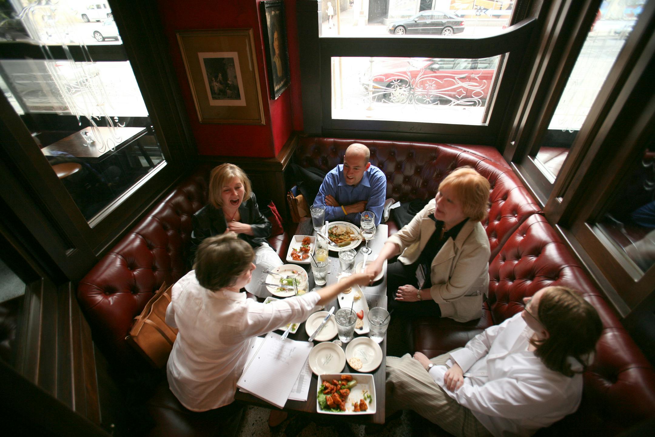 JEFF WHEELER &#xa5; jwheeler@startribune.com MINNEAPOLIS - 5/28/07 - The Local, the popular Nicollet Mall watering hole, has remodeled the street side of the establishment and now features cut glass-enclosed nooks for customers to snuggle in. They're called "snugs." IN THIS PHOTO: A group of five educaton administrators in town for a conference took to one of the snugs for dinner and conversation Sunday evening at The Local. They are, clockwise from lower left, Heather Meacham-Thompson, Mary Dan