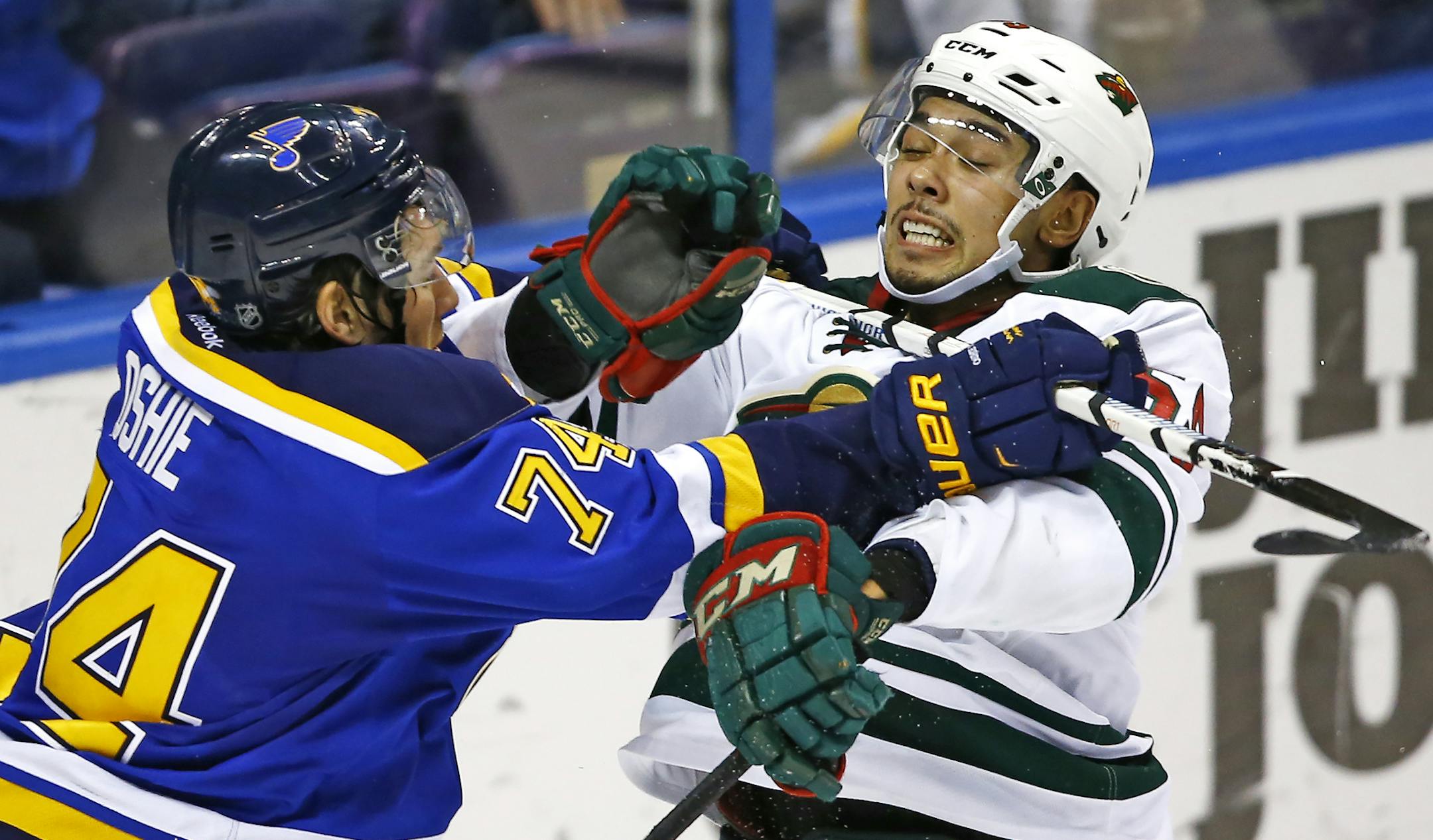 St. Louis Blues' T.J. Oshie, left, checks Minnesota Wild's Matt Dumba during the third period of an NHL hockey game Saturday, March 14, 2015, in St. Louis. Minnesota won the game 3-1. (AP Photo/Billy Hurst)