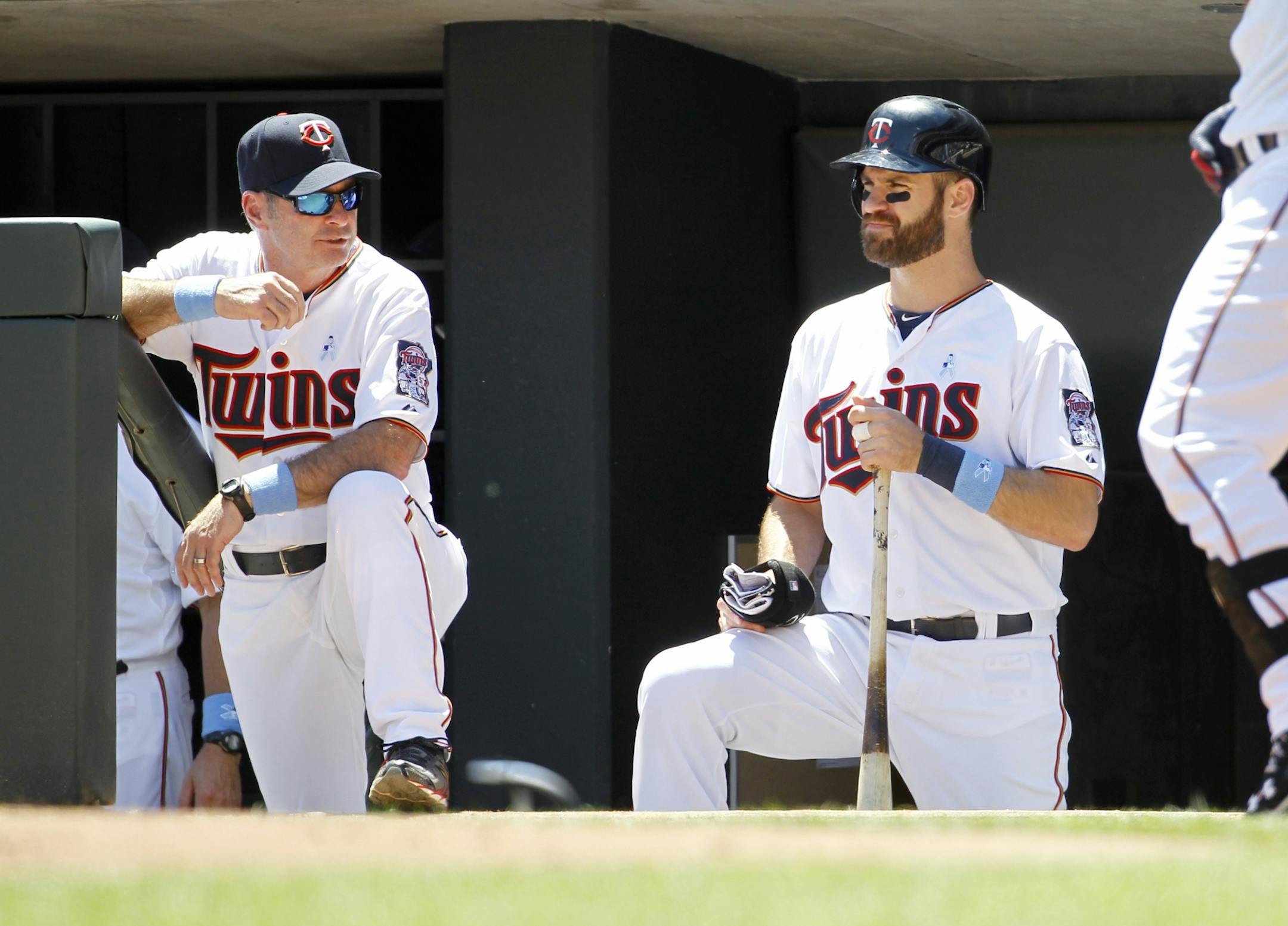 Minnesota Twins first baseman Joe Mauer, right, stands with manager Paul Molitor, left, during the first inning of a baseball game against the Chicago Cubs in Minneapolis, Sunday, June 21, 2015.