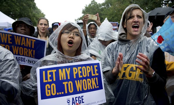 Jennifer Li and Brennan Andrews, both of the American Federation of Government Employees, demonstrate during the "Stop the Lockout" rally against the 