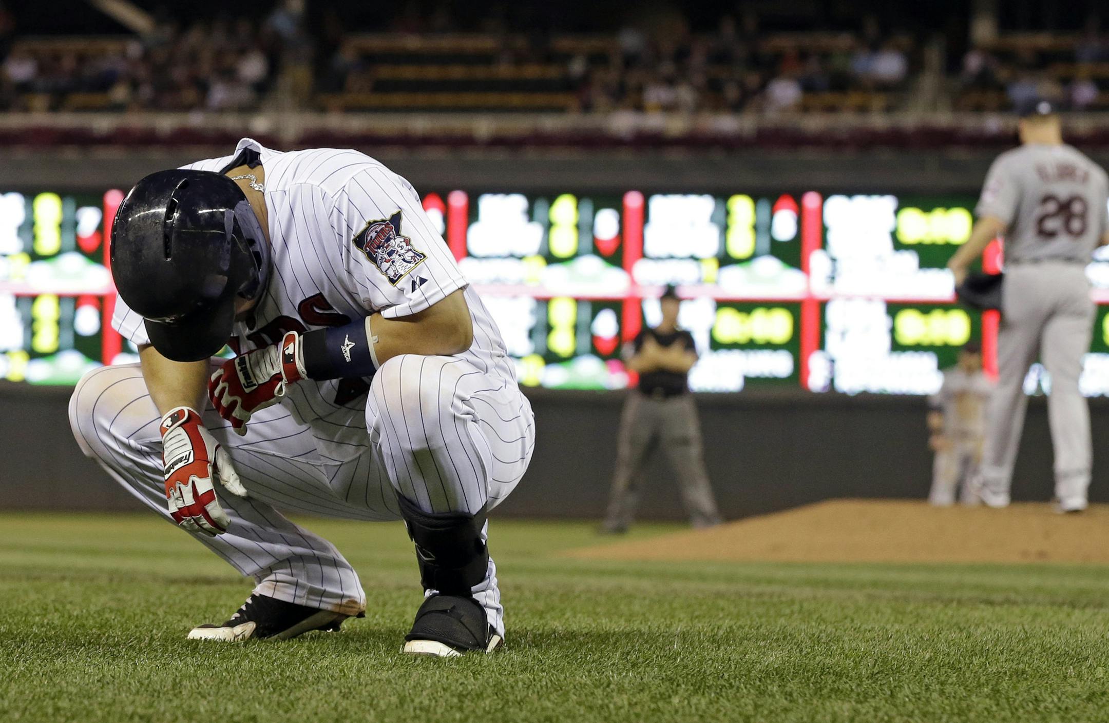 Minnesota Twins' Josmil Pinto gathers himself after he was hit by a pitch from Cleveland Indians' Corey Kluber, right, in the fourth inning of a baseball game on Friday, Sept. 27, 2013, in Minneapolis. Pinto left the game with a bruised right hand. (AP Photo/Jim Mone)