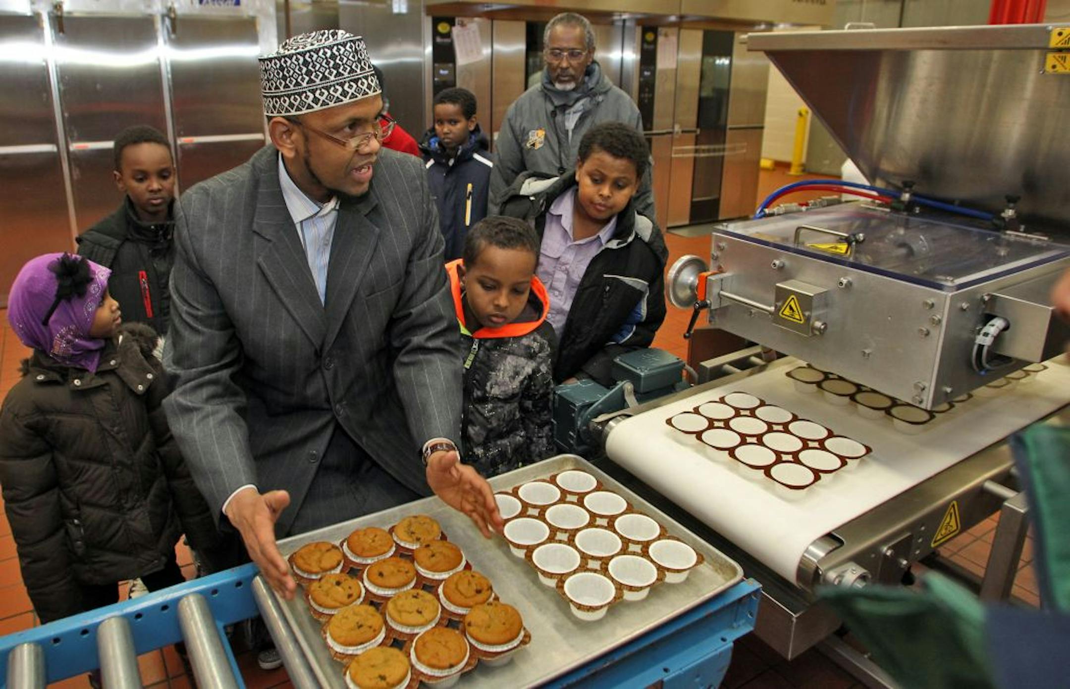 Members of the Somali Parent Advisory Council toured the St. paul school district's nutrition center as part of an outreach between the district and various ethnic groups. A tour through the kitchen where school lunches are prepared was part of the agenda. Sharif Mohamed, parent of children attending St. paul schools, asked questions about bakery machinery.(MARLIN LEVISON/STARTRIBUNE(mlevison@startribune.com