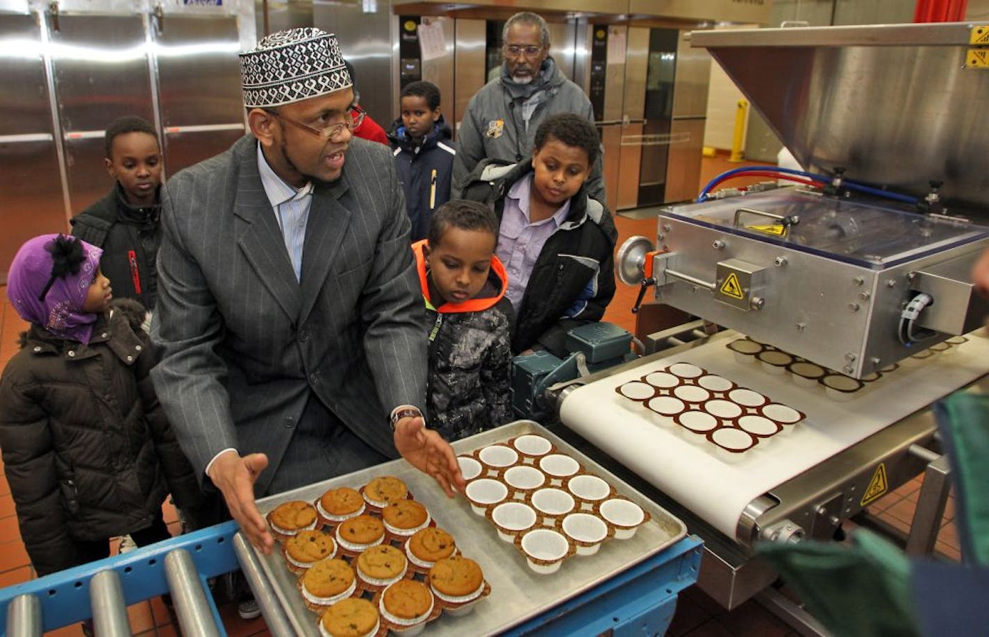 Members of the Somali Parent Advisory Council toured the St. paul school district's nutrition center as part of an outreach between the district and various ethnic groups. A tour through the kitchen where school lunches are prepared was part of the agenda. Sharif Mohamed, parent of children attending St. paul schools, asked questions about bakery machinery.
(MARLIN LEVISON/STARTRIBUNE(mlevison@startribune.com