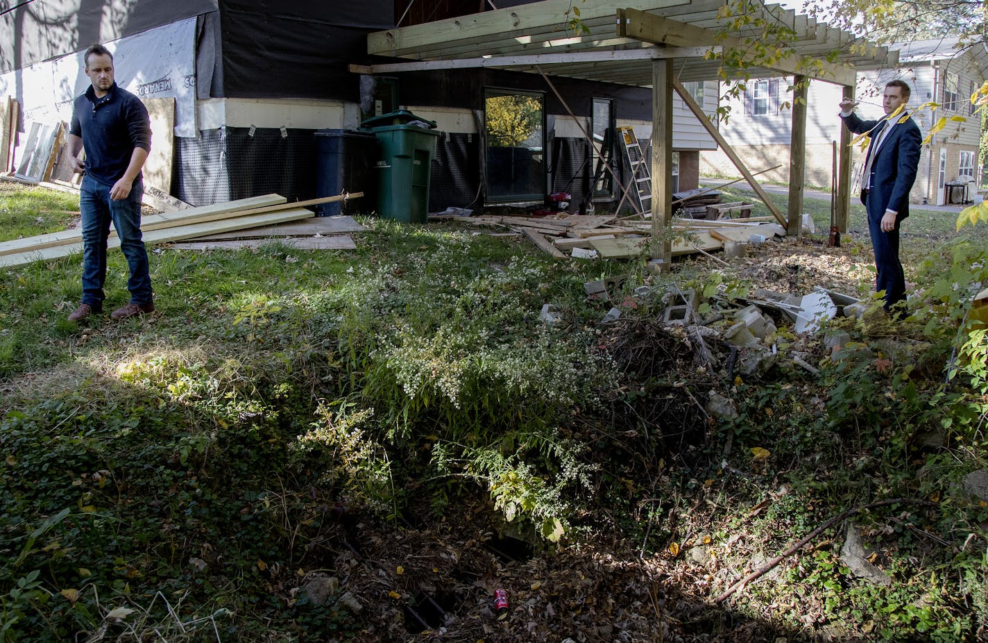 Josh Hague and his attorney Andrew Pieper stood in his backyard, which has been flooding, do to an overflow of water. ] CARLOS GONZALEZ &#xef; cgonzalez@startribune.com - October 18, 2017, Mahtomedi, MN, Five Mahtomedi homeowners have sued the city, claiming officials reneged on a negotiated agreement to pay damages for a faulty street improvement project.