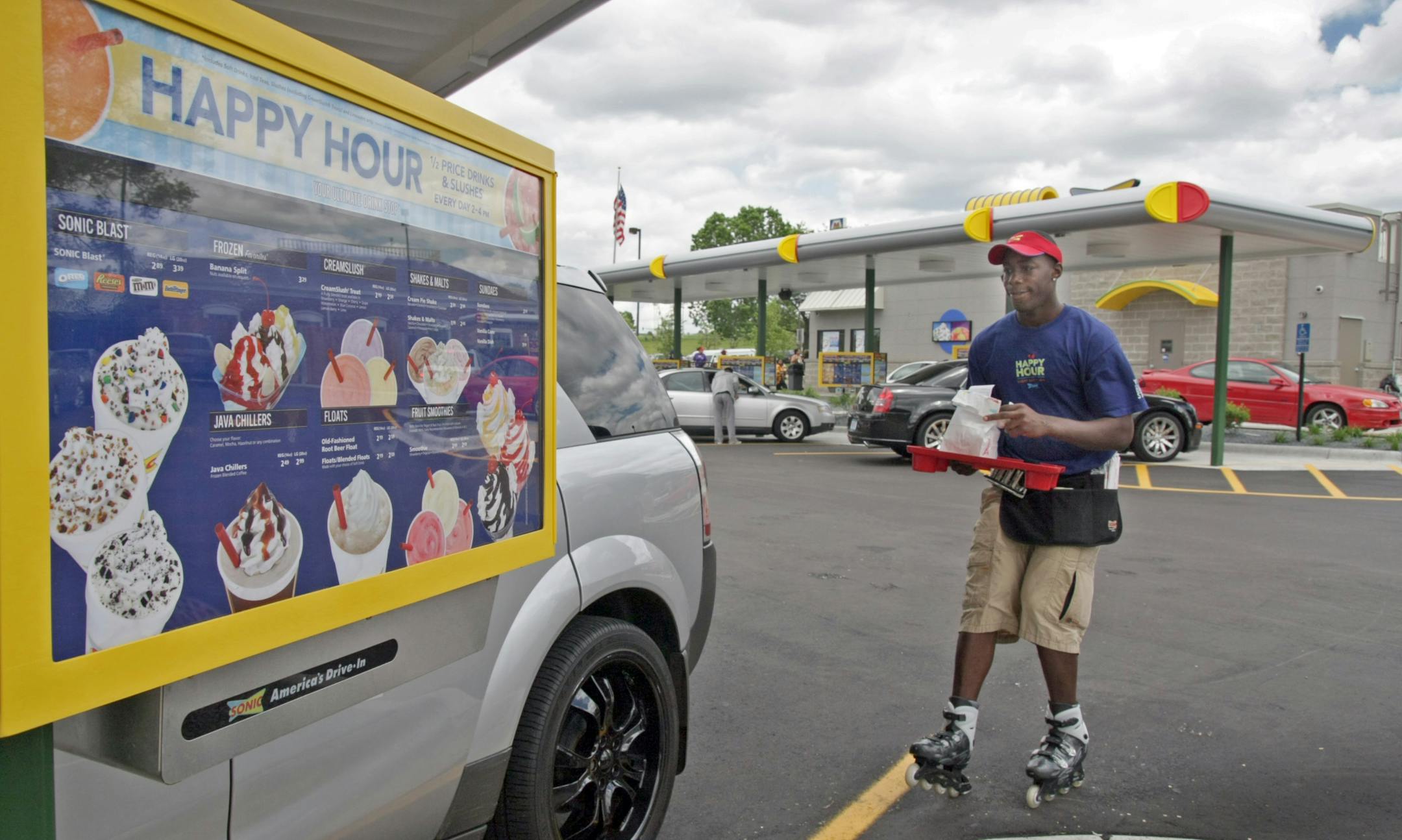 'Car-hop" Steve Estus skates up to car with the order on a tray at the newly opened Sonic drive-in