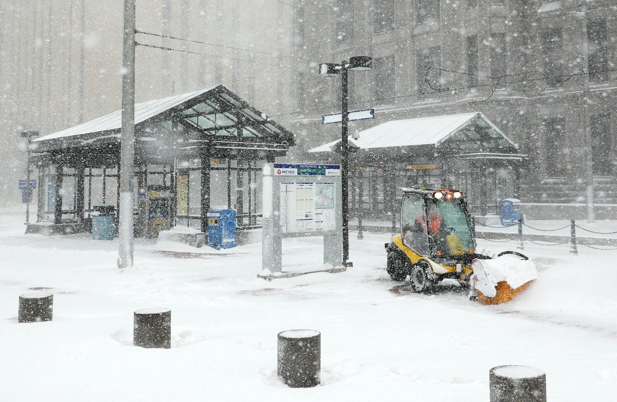 A worker tried to clear snow and ice from the Metro Government Center Plaza station as the snow picked up in downtown Minneapolis. ] ANTHONY SOUFFLE ï anthony.souffle@startribune.com The city was blanked by a snowstorm that dropped rain and sleet before turning to snow Saturday, April 14, 2018 in Minneapolis.