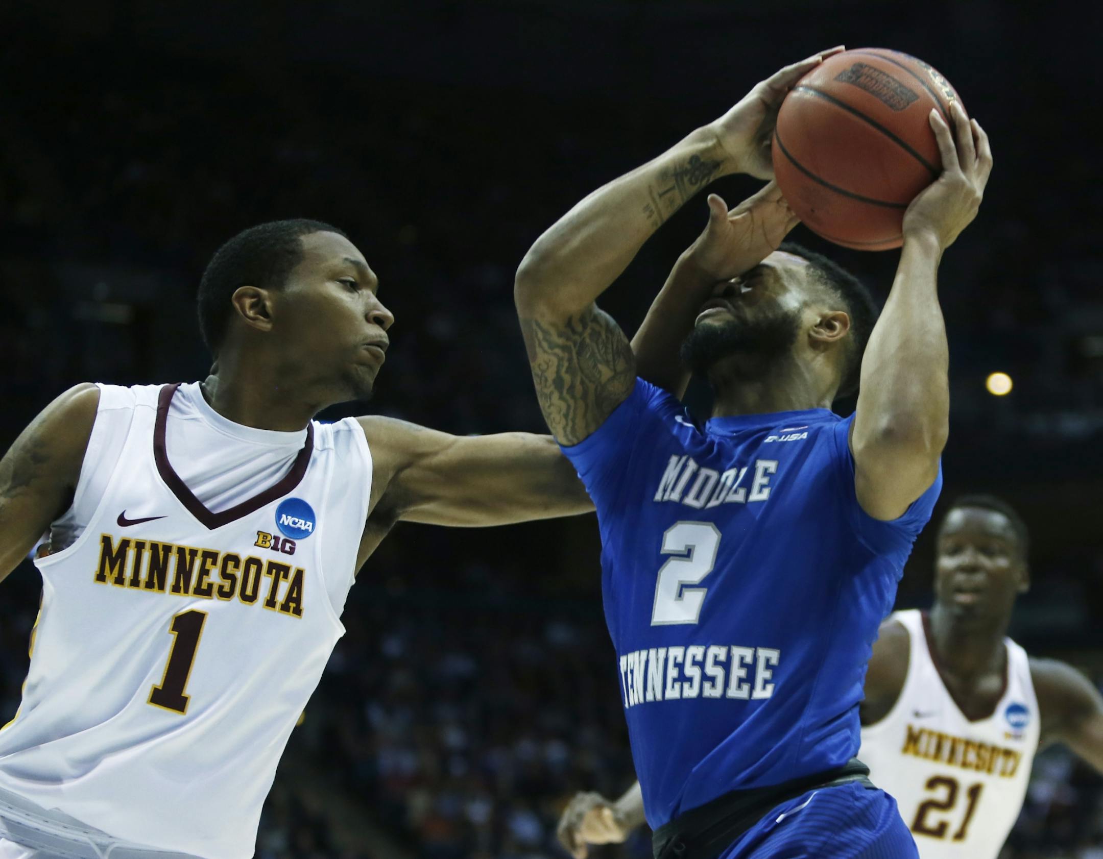 Middle Tennessee's Antwain Johnson (2) is hit in the face as he drives past Minnesota's Dupree McBrayer (1) during the first half of an NCAA college basketball tournament first round game Thursday, March 16, 2017, in Milwaukee.