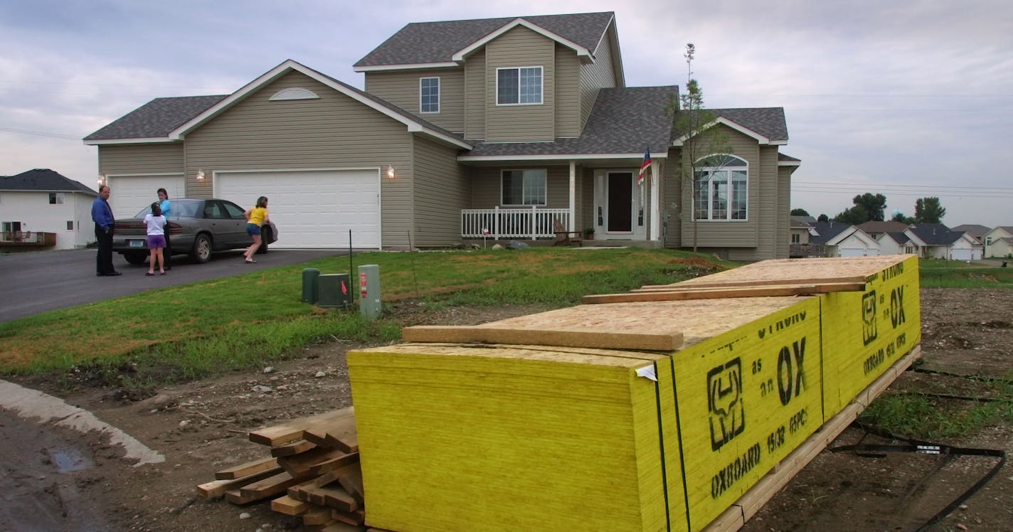 IN THIS PHOTO: Shakopee, MN., Tuesday, 7/24/2001. A pile of lumber soon to be used in new home construction sat in the vacant lot next to the home of Bill Mars and Corinne Beeson in Shakopee. Builders say a shortage of lots high land prices have been a contribued to housing price increases. Land shortages in the 7-county metro area are forcing builders _ and buyers _ to shop in communities on the metro area fringe. Shakopee, for example, led the pack in the number of permits issued during the fi