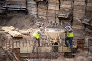 John Keeley, left, and Matthew Jansen of Municipal Builders Inc. pour concrete at the site of the water treatment plant Monday in South St Paul.