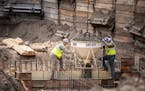 John Keeley, left, and Matthew Jansen of Municipal Builders Inc. pour concrete at the site of the water treatment plant Monday in South St Paul.