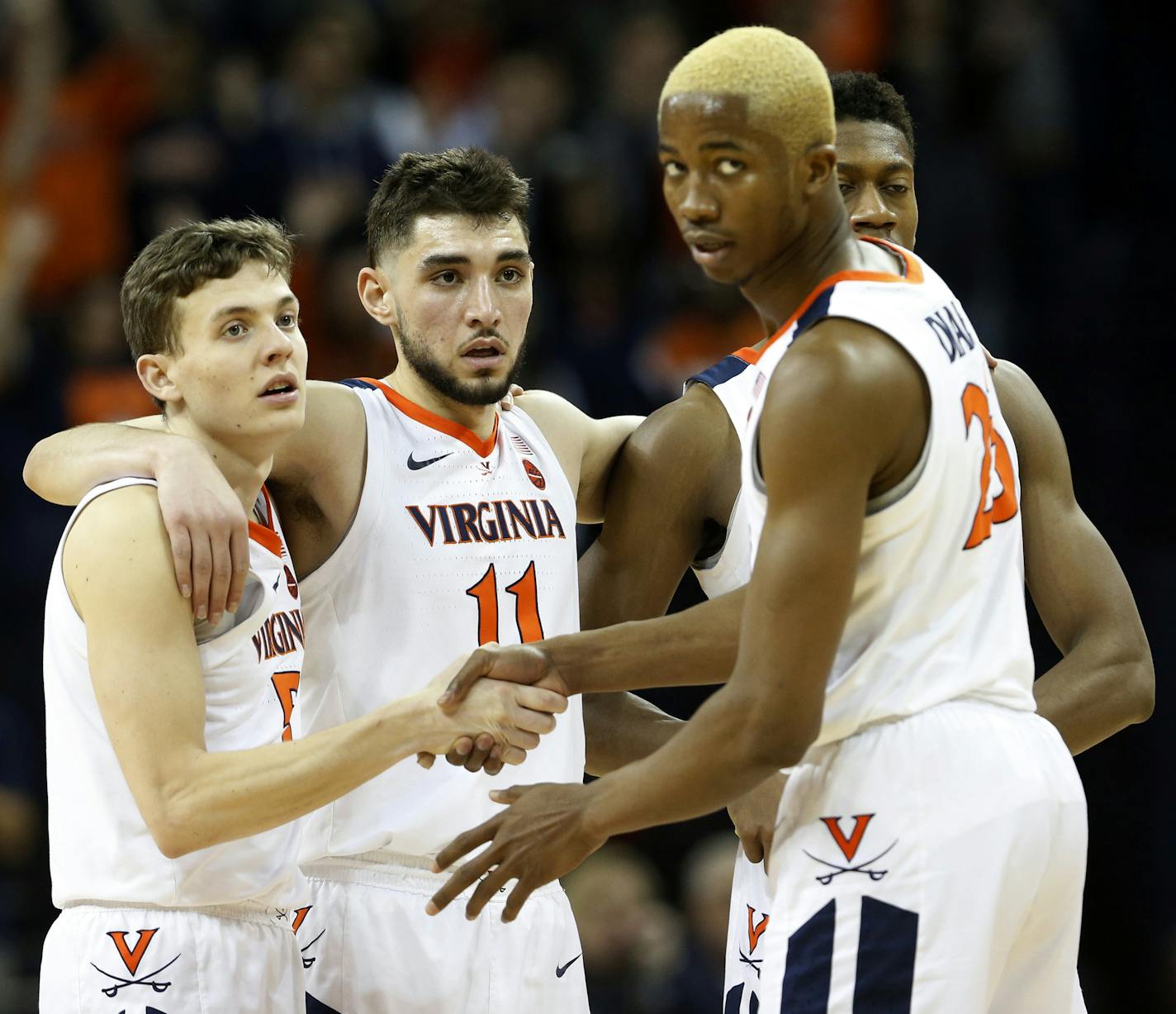 Virginia guard Kyle Guy (5), Ty Jerome (11) and forward Mamadi Diakite (25) watch a foul shot during the second half of an NCAA college basketball game against Louisville in Charlottesville, Va., Saturday, March 9, 2019. (AP Photo/Steve Helber)