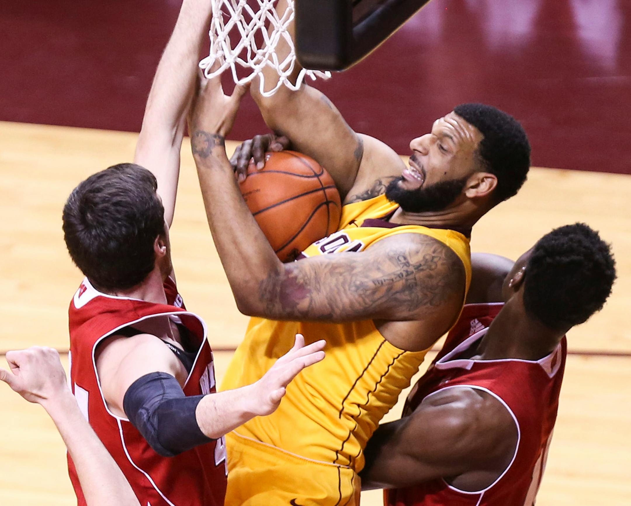 Wisconsin's Frank Kaminsky (44) and Nigel Hayes (10) piled in on Minnesota's Maurice Walker to stop him from scoring during the first half.