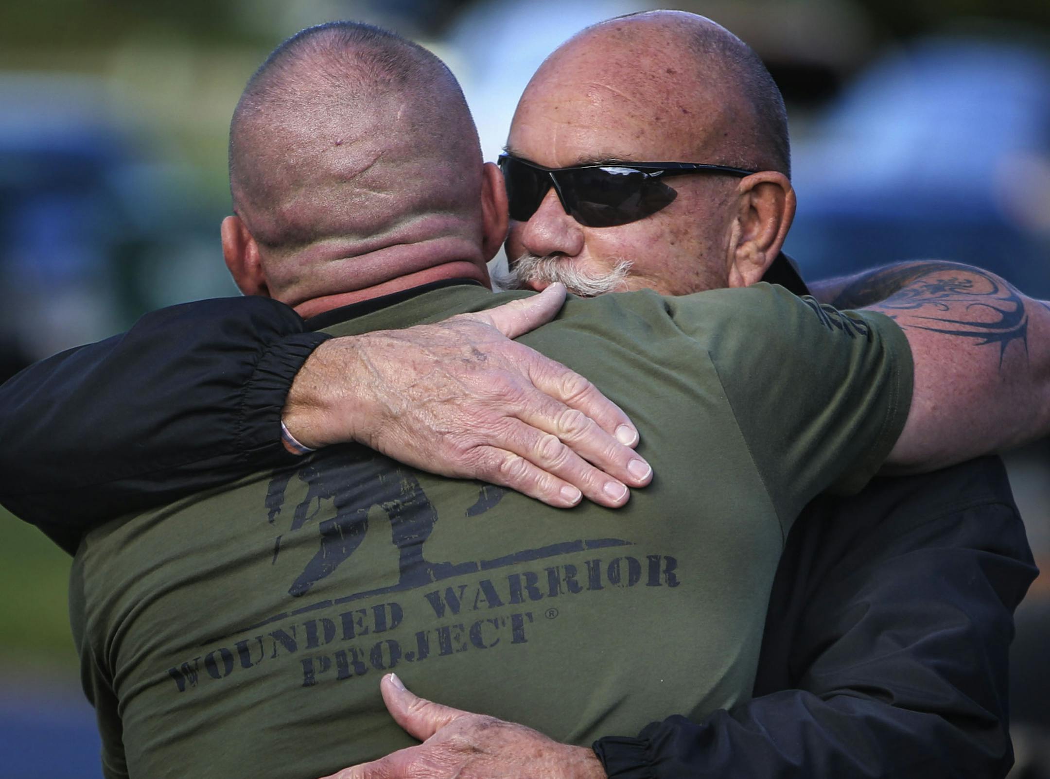 Army veteran Joel Sigfrid, who while deployed to Afghanistan, suffered a severe traumatic brain injury from an IED that injured him and his 12-man crew, received a home Tuesday, Oct. 7, 2014, in Blaine, MN. Here, Sigfrid, back to the camera, was greeted by hugs from family and friends as he arrived at his new home.](DAVID JOLES/STARTRIBUNE)djoles@startribune.com Wells Fargo Mortgage and Military Warriors Support Foundation are giving a home to Army veteran Joel Sigfrid on Tuesday. Originally fro