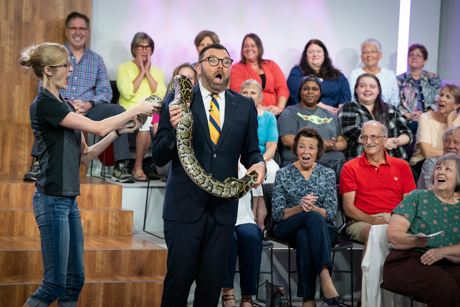 Jason Matheson tapes a segment for “The Jason Show” with a Burmese python from Snake Discovery in Maplewood with owner Emily Roberts at the Fox 9 studio in Eden Prairie.