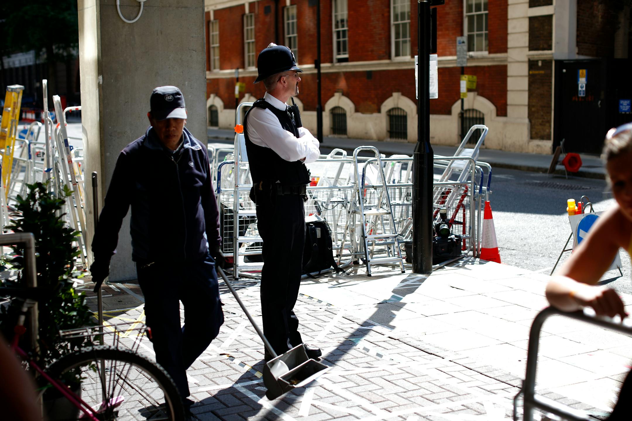 A British police office stands near media stepladders across the street from the main entrance of St. Mary's Hospital Lindo Wing in London, Tuesday, July 9, 2013. Media outlets are marking positions outside the building where Britain's Prince William and his wife Kate are expecting their first child to be born in mid-July. (AP Photo/Matt Dunham)