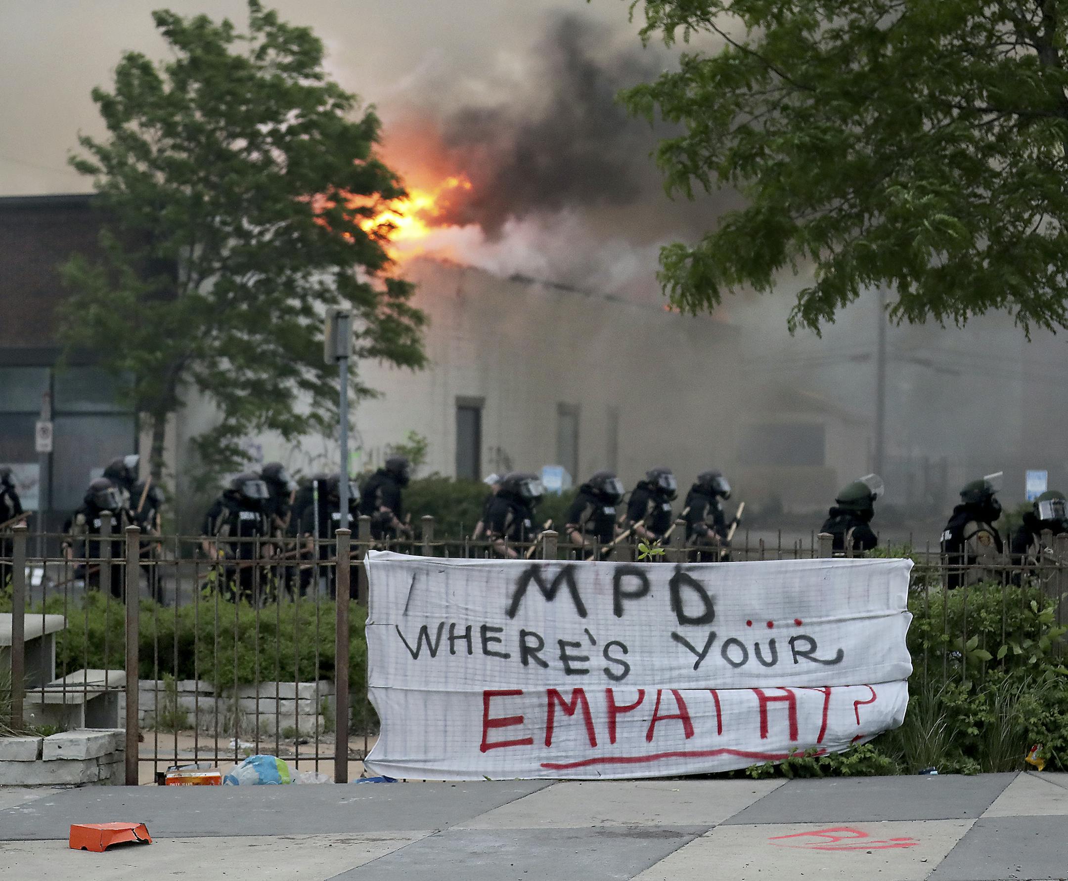 Law enforcement officers protect Minneapolis fire fighters along Lake Street as fires burned after a night of unrest and protests in the death of George Floyd early Friday, May 29, 2020 in Minneapolis. Floyd died after being restrained by Minneapolis police officers on Memorial Day. (David Joles/Star Tribune via AP)