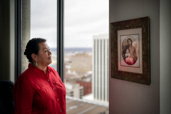 Juliet Rudie, the new director of the Missing and Murdered Indigenous Relatives office, looks at a portrait of her great-great grandmother holding her