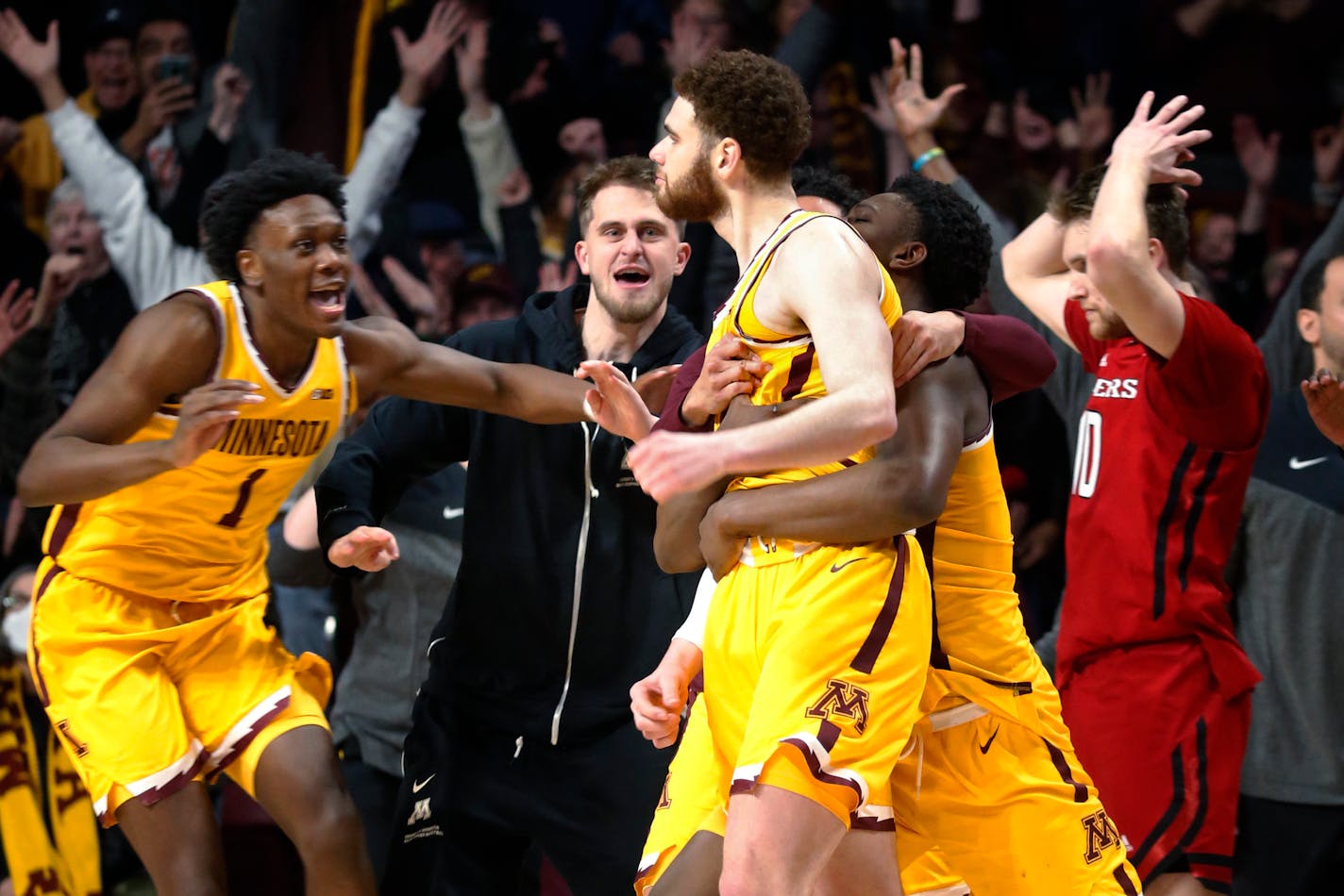 Minnesota forwards Joshua Ola-Joseph (1) and Pharrel Payne, right, celebrate the game-winning 3-point basket by Jamison Battle, center, against Rutgers in an NCAA college basketball game Thursday, March 2, 2023, in Minneapolis. Minnesota won 75-74. (AP Photo/Bruce Kluckhohn)