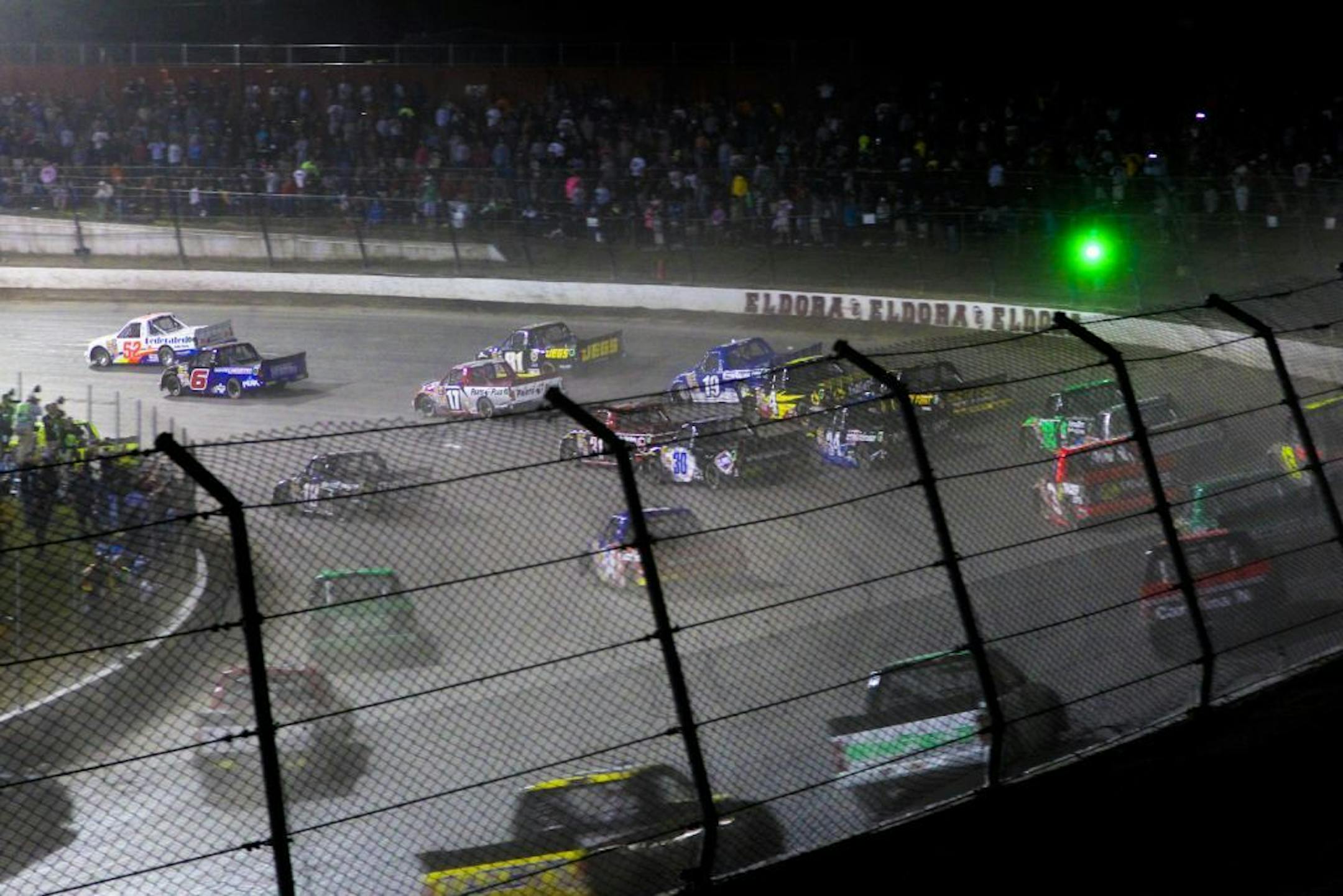 Drivers head through a turn on the opening lap of the NASCAR Truck Series auto race Wednesday, July 24, 2013, on the dirt at Eldora Speedway in Rossburg, Ohio. (AP Photo/Dayton Daily News, Greg Lynch) LOCAL PRINT OUT AND LOCAL TV OUT