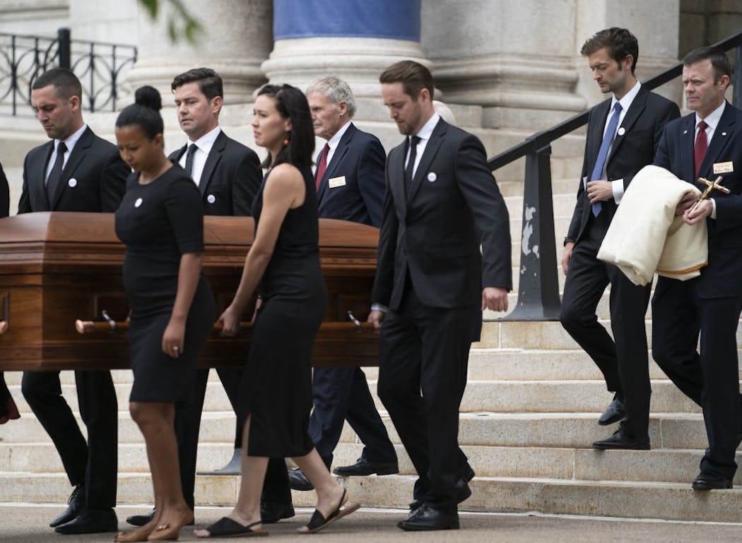 Gabe Grunewald's husband, Justin, followed her casket at her funeral out of the Basilica of St. Mary in Minneapolis on Monday.