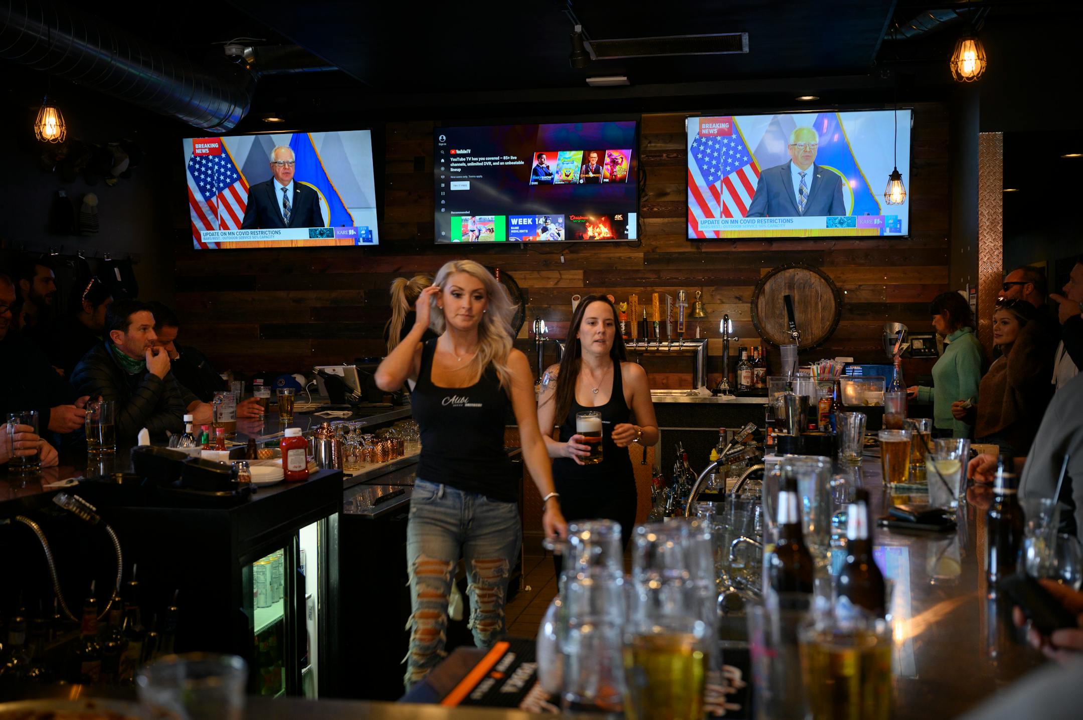As workers served patrons at Alibi Drinkery in Lakeville, Gov. Tim Walz was broadcast by KARE11 in the background, talking about COVID restrictions.