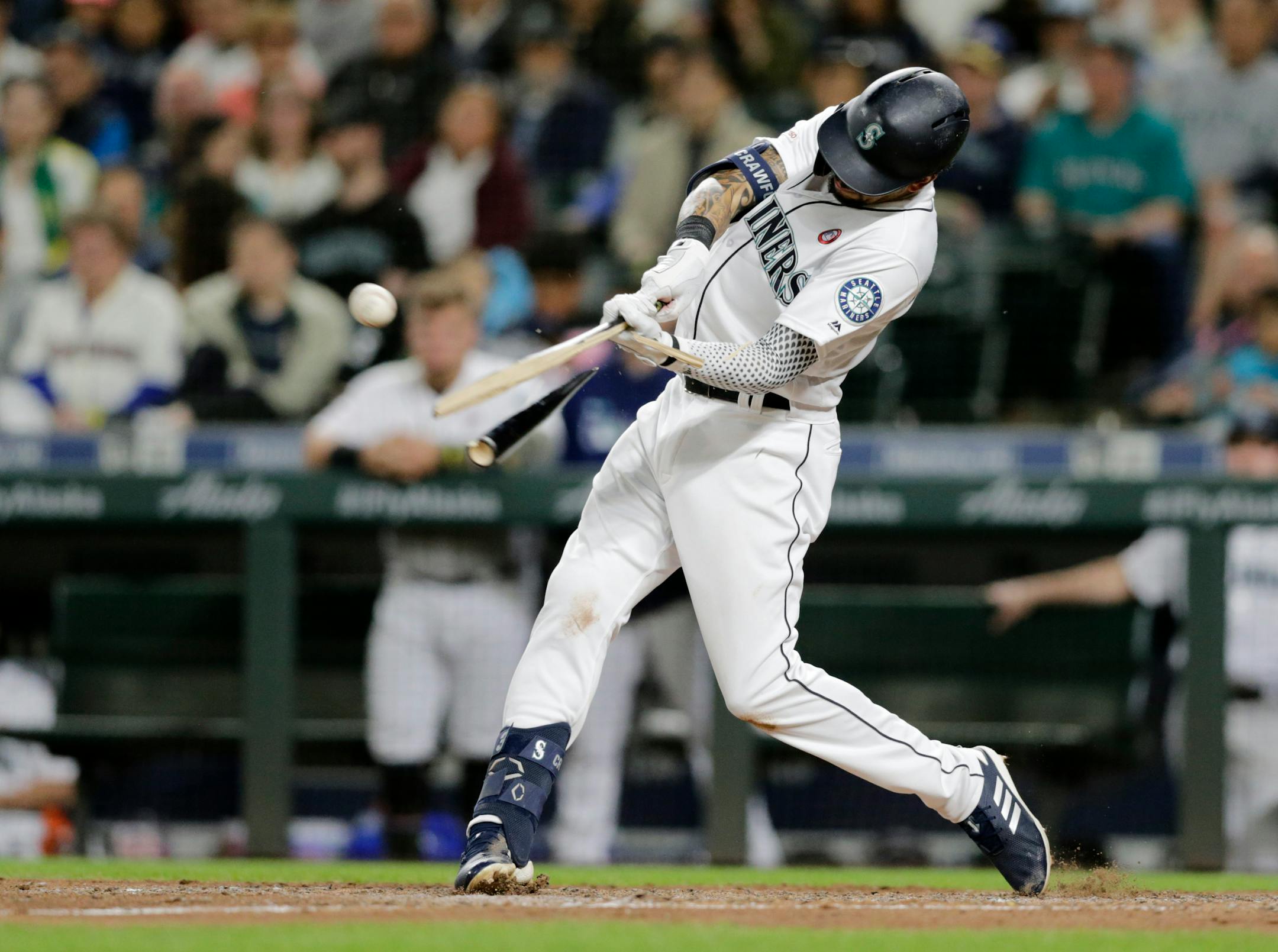 Seattle Mariners' J.P. Crawford breaks his bat on an RBI single against the Minnesota Twins during the fifth inning of a baseball game Saturday, May 18, 2019, in Seattle. (AP Photo/John Froschauer)