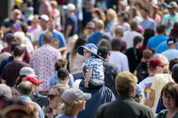 Eddie Hoeschen, 2, rode on his grandpa Kevin Hoeschen's, of Duluth, shoulders as they walked through a thick crowd at the Minnesota State Fair in Falc