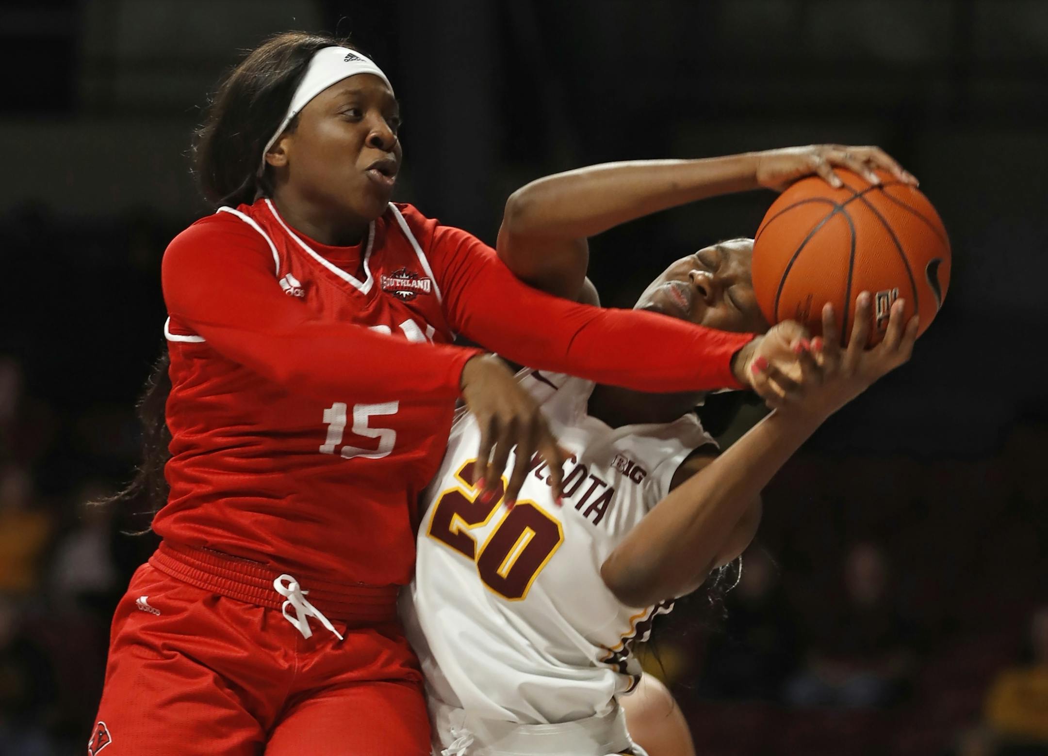 Starr Omozee(15) tries to get the ball away from Gophers Charmaine McBride(20).