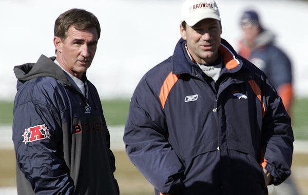 Denver Broncos head coach Mike Shanahan, left, and offensive coordinator Gary Kubiak watch their team during practice at the Broncos training facility