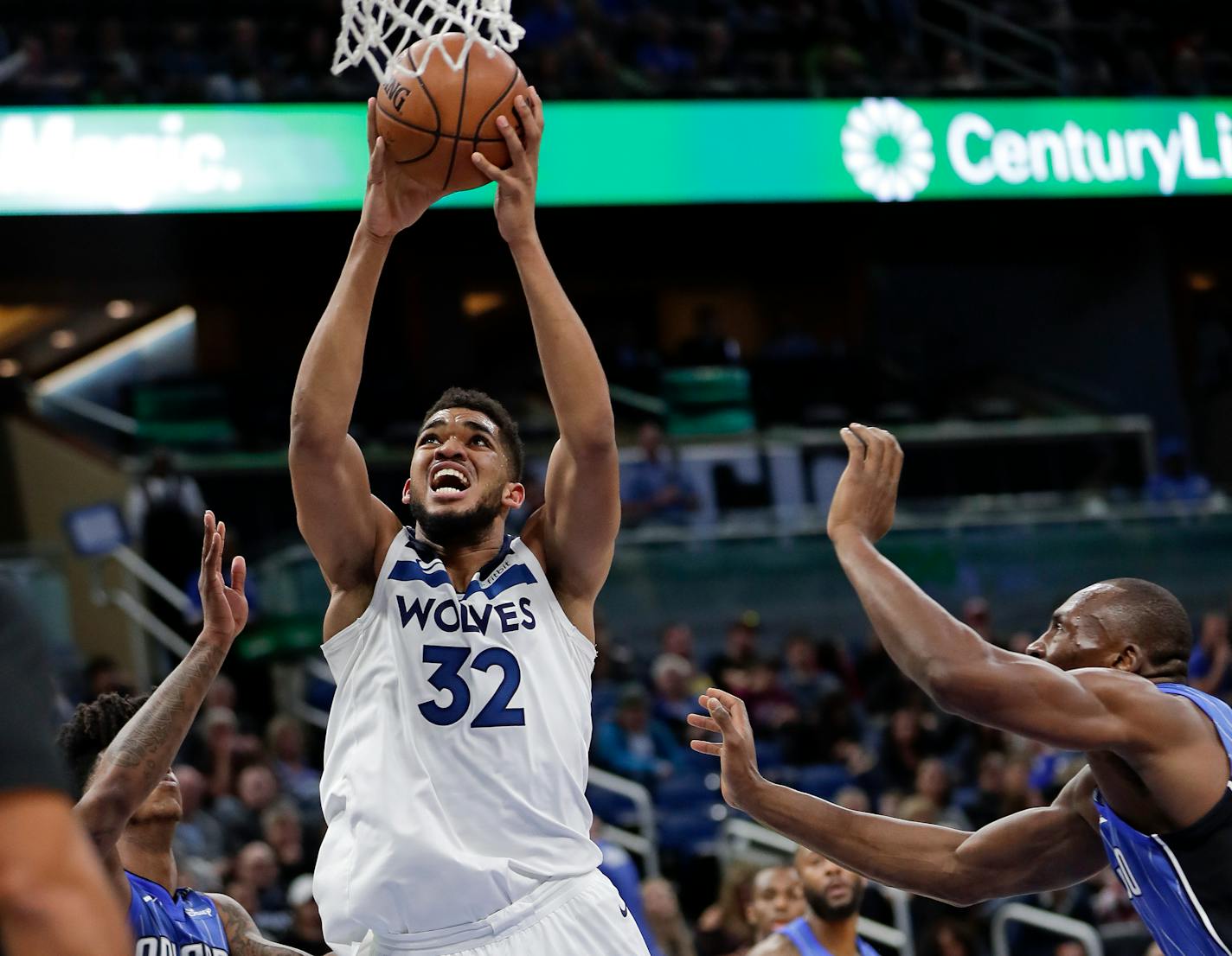 Minnesota Timberwolves' Karl-Anthony Towns makes a shot as he gets between Orlando Magic's Elfrid Payton, left, and Bismack Biyombo, right, during the first half of an NBA basketball game, Tuesday, Jan. 16, 2018, in Orlando, Fla. (AP Photo/John Raoux)