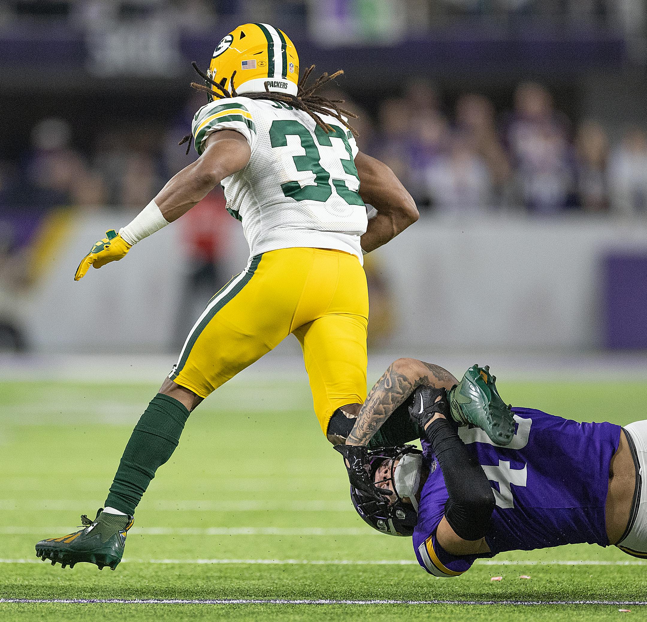 Vikings linebacker Ivan Pace Jr. (40) holds onto Packers running back Aaron Jones (33) in the second quarter at U.S. Bank Stadium, in Minneapolis, Minn., on Sunday, Dec. 31, 2023. ] Elizabeth Flores • liz.flores@startribune.com
